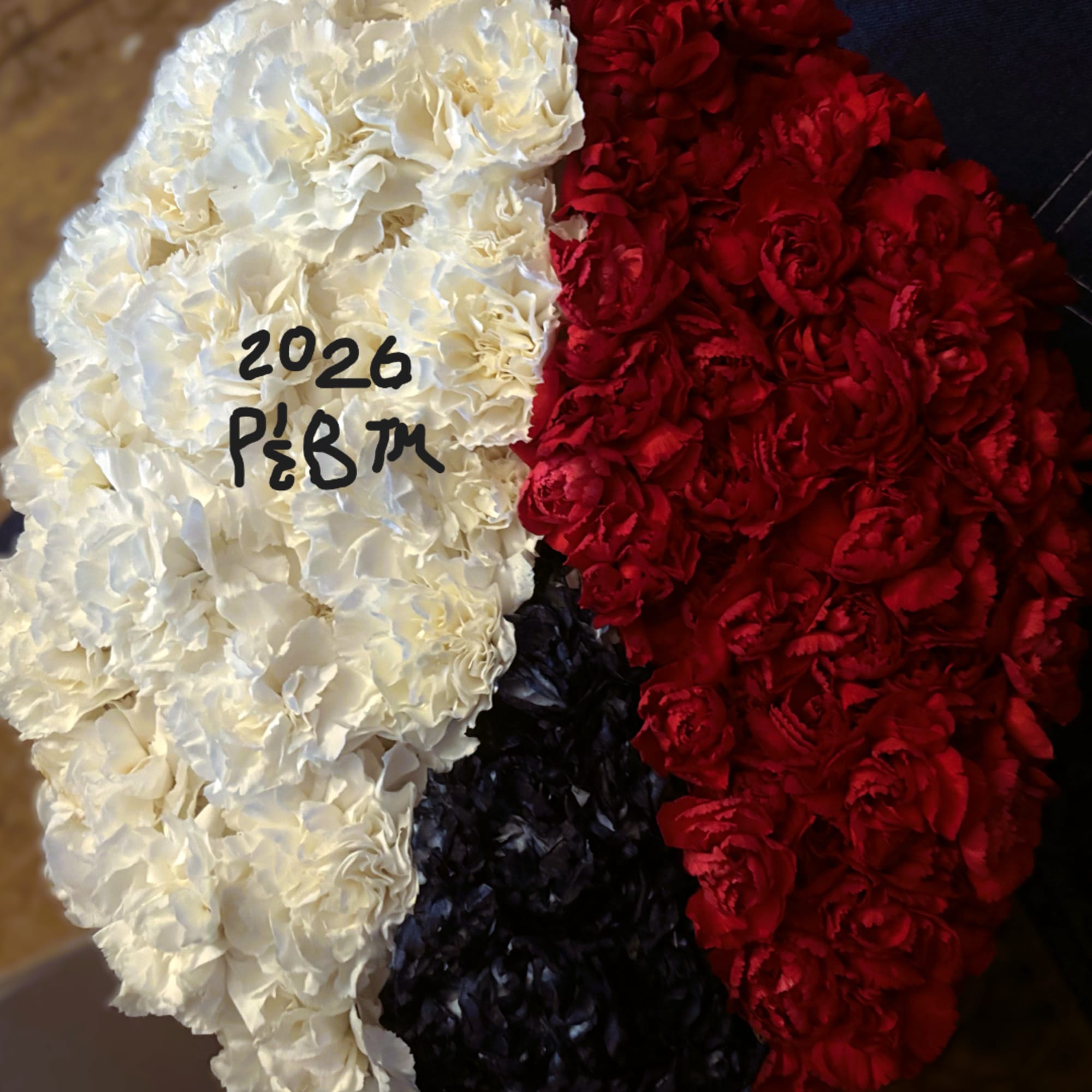 Red, white, and black floral arrangement with handwritten text on the white section