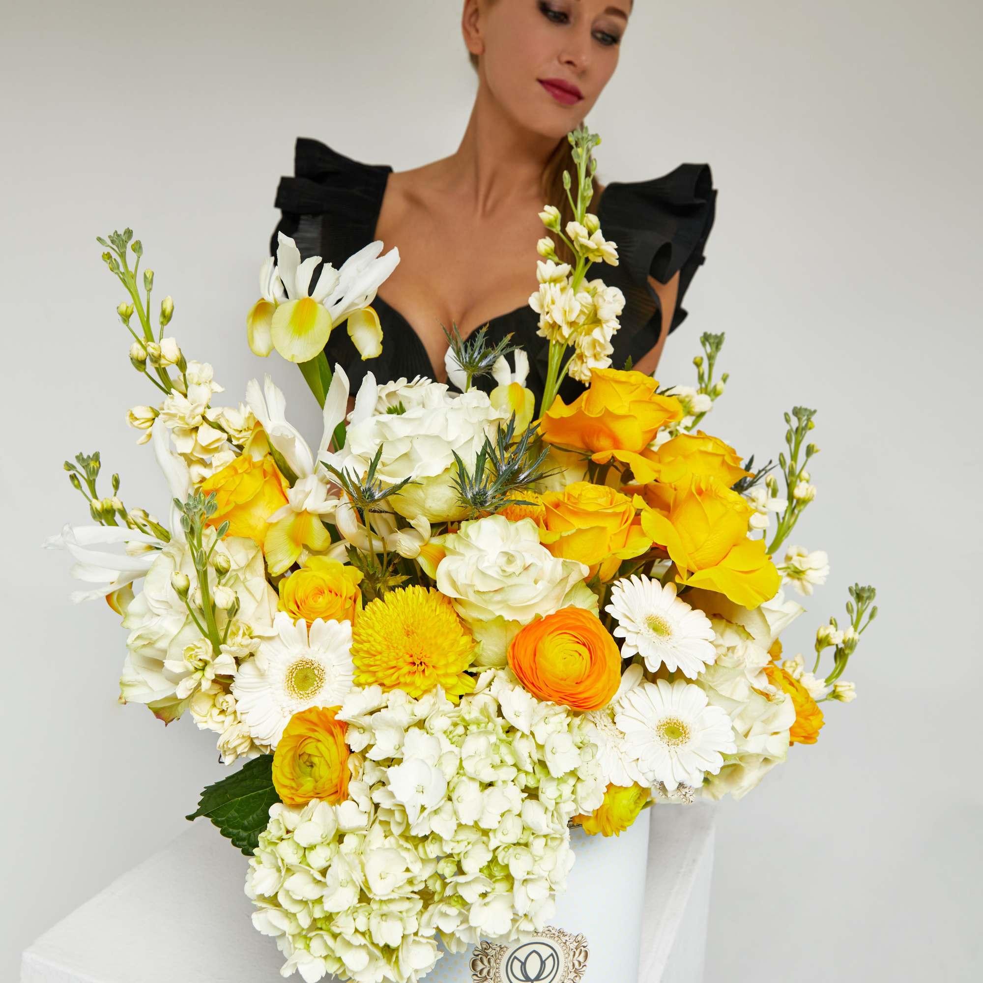 Large bouquet of white and yellow flowers in a white hatbox