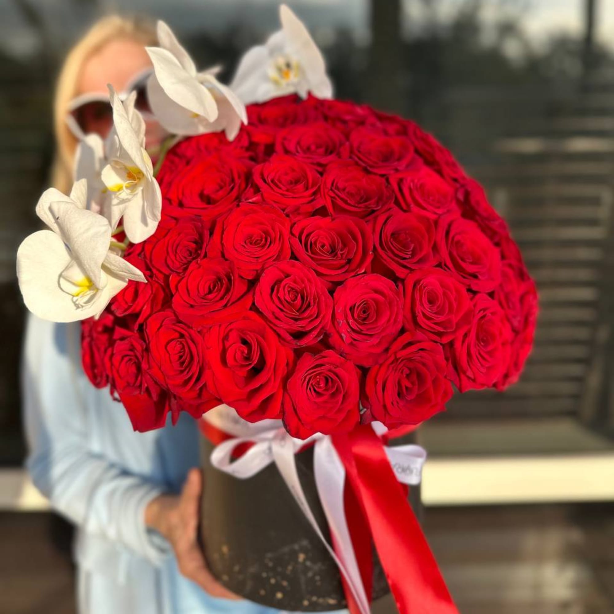 Large bouquet of red roses with white orchids in a black box