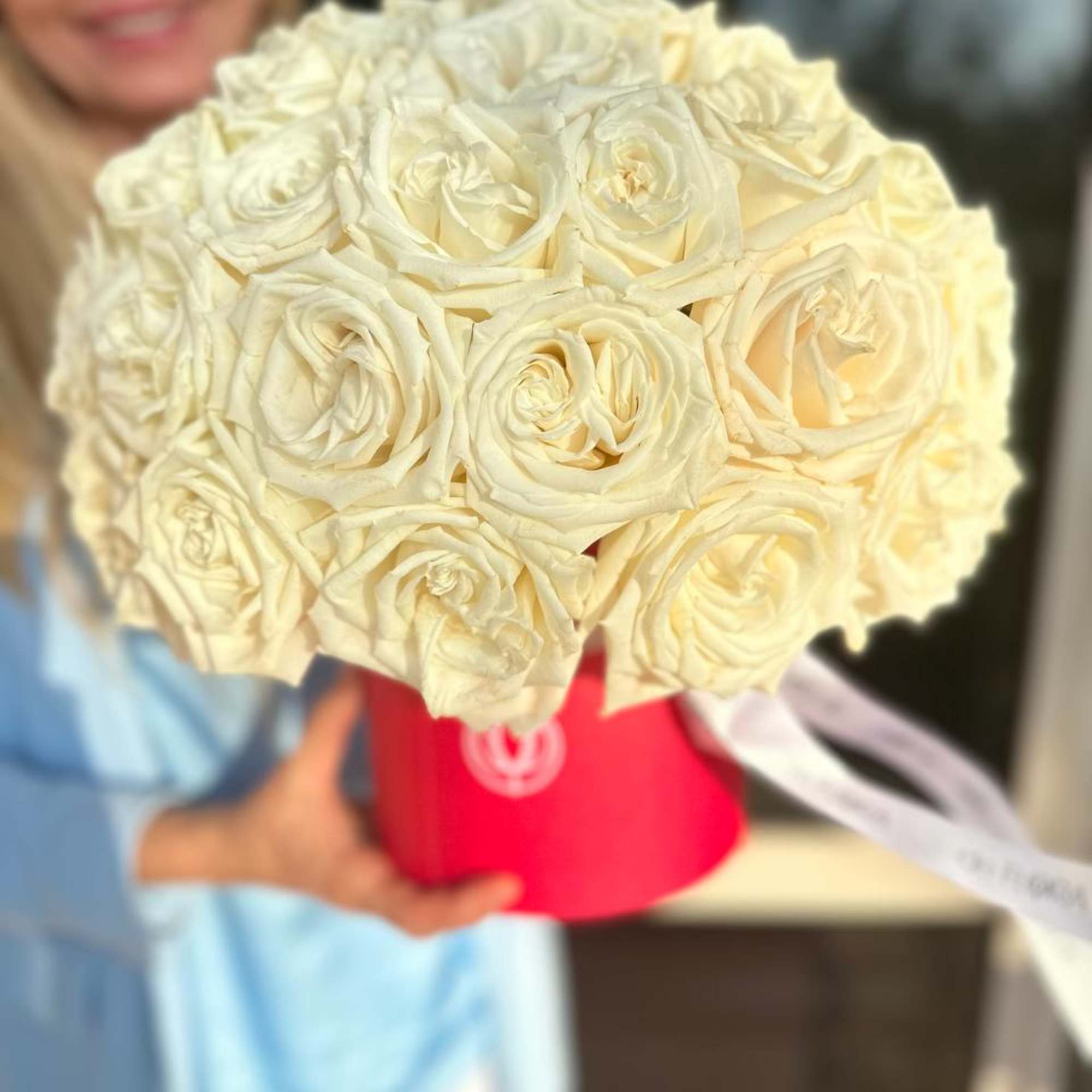 Bouquet of cream roses in a red hat box