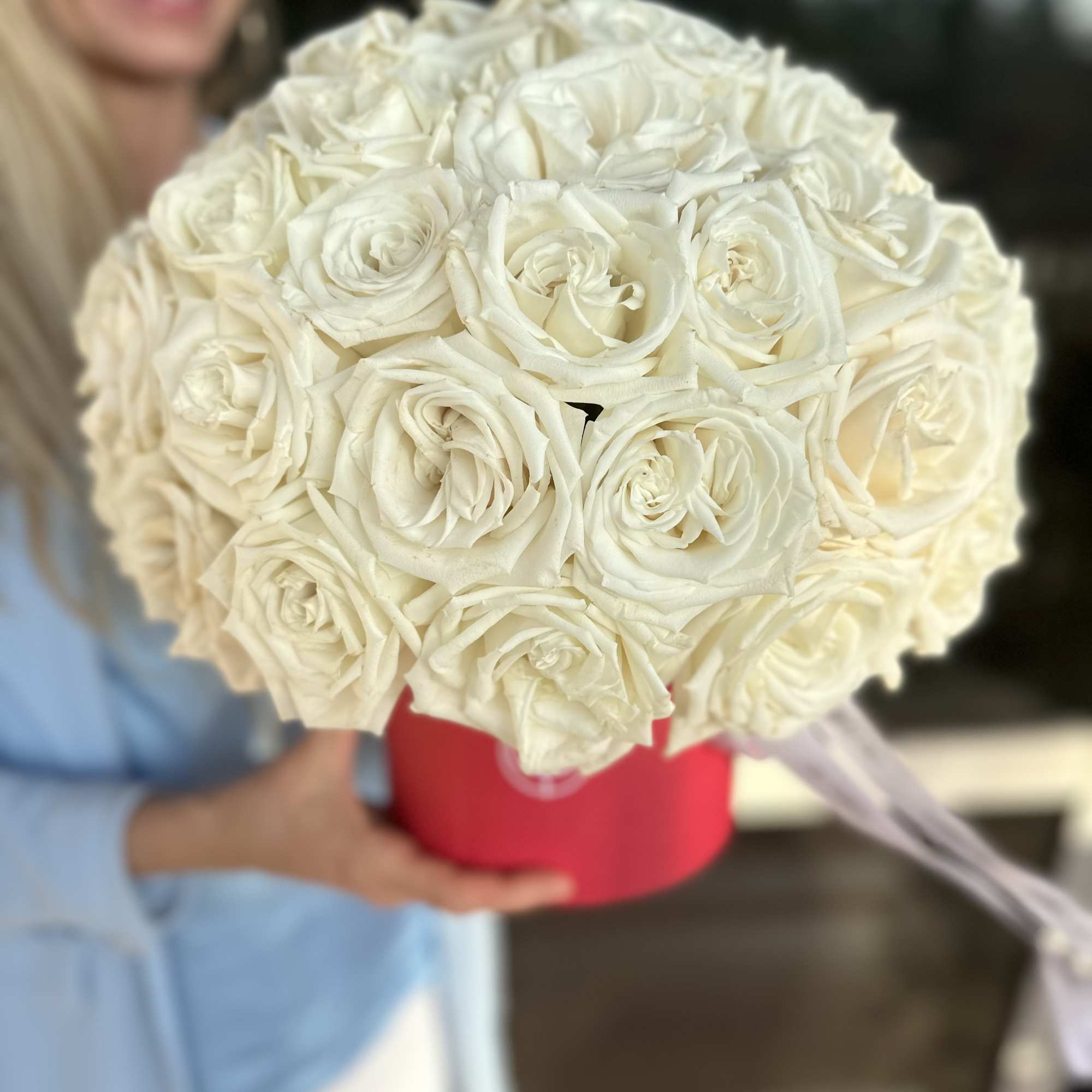 Large bouquet of white roses in a red hat box