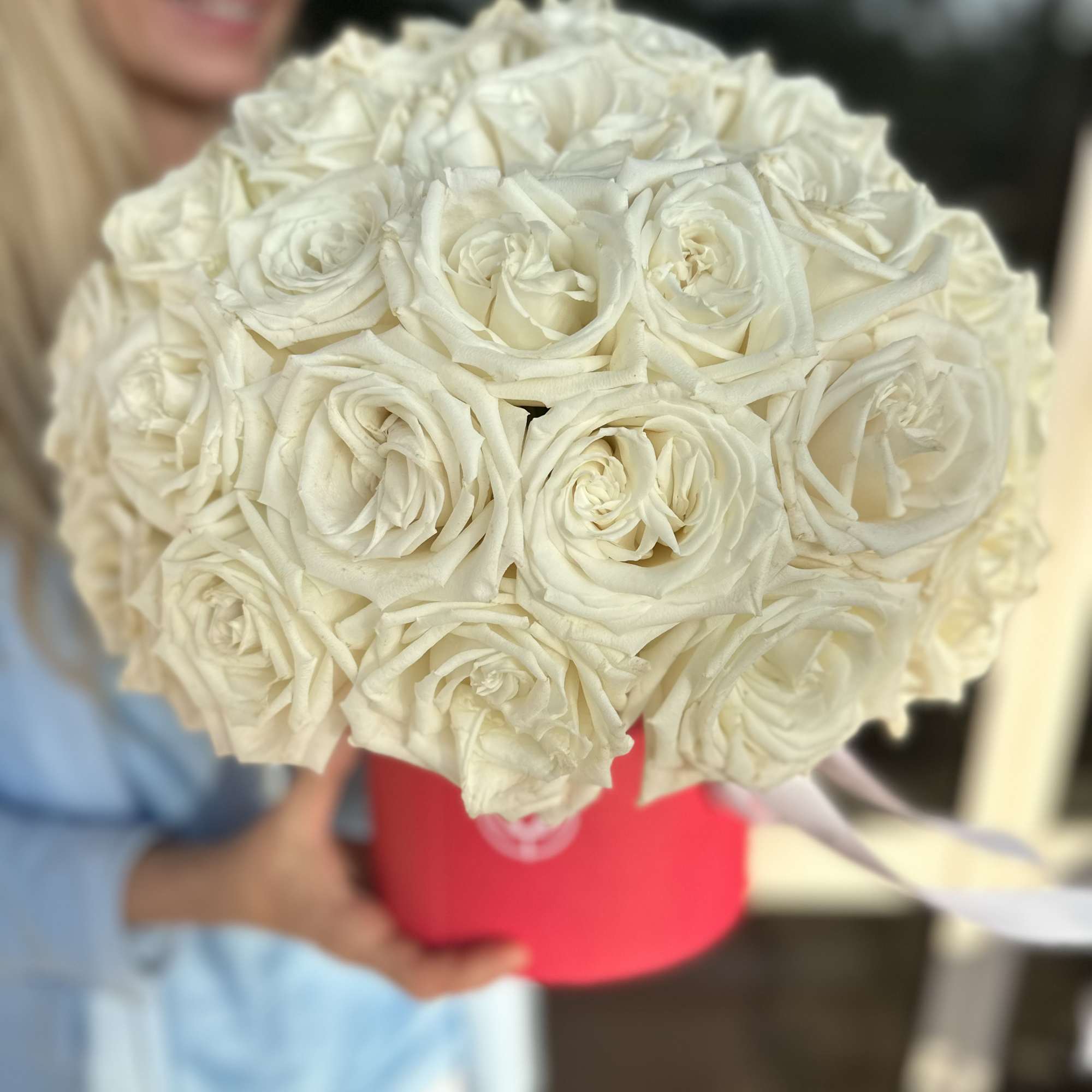 Bouquet of white roses in a pink hatbox