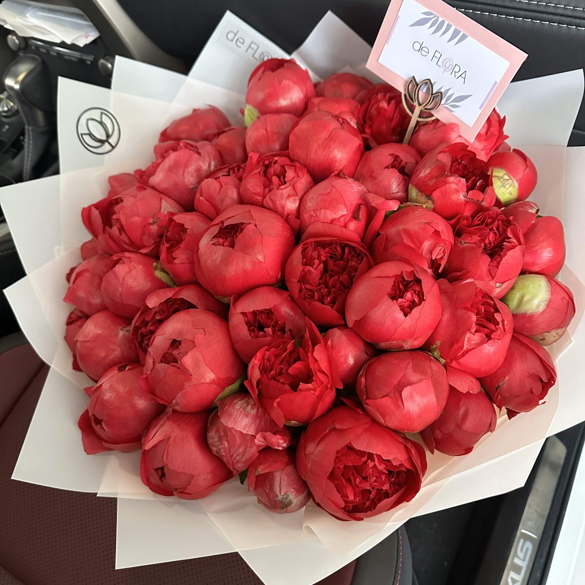 Bouquet of red peonies wrapped in white paper