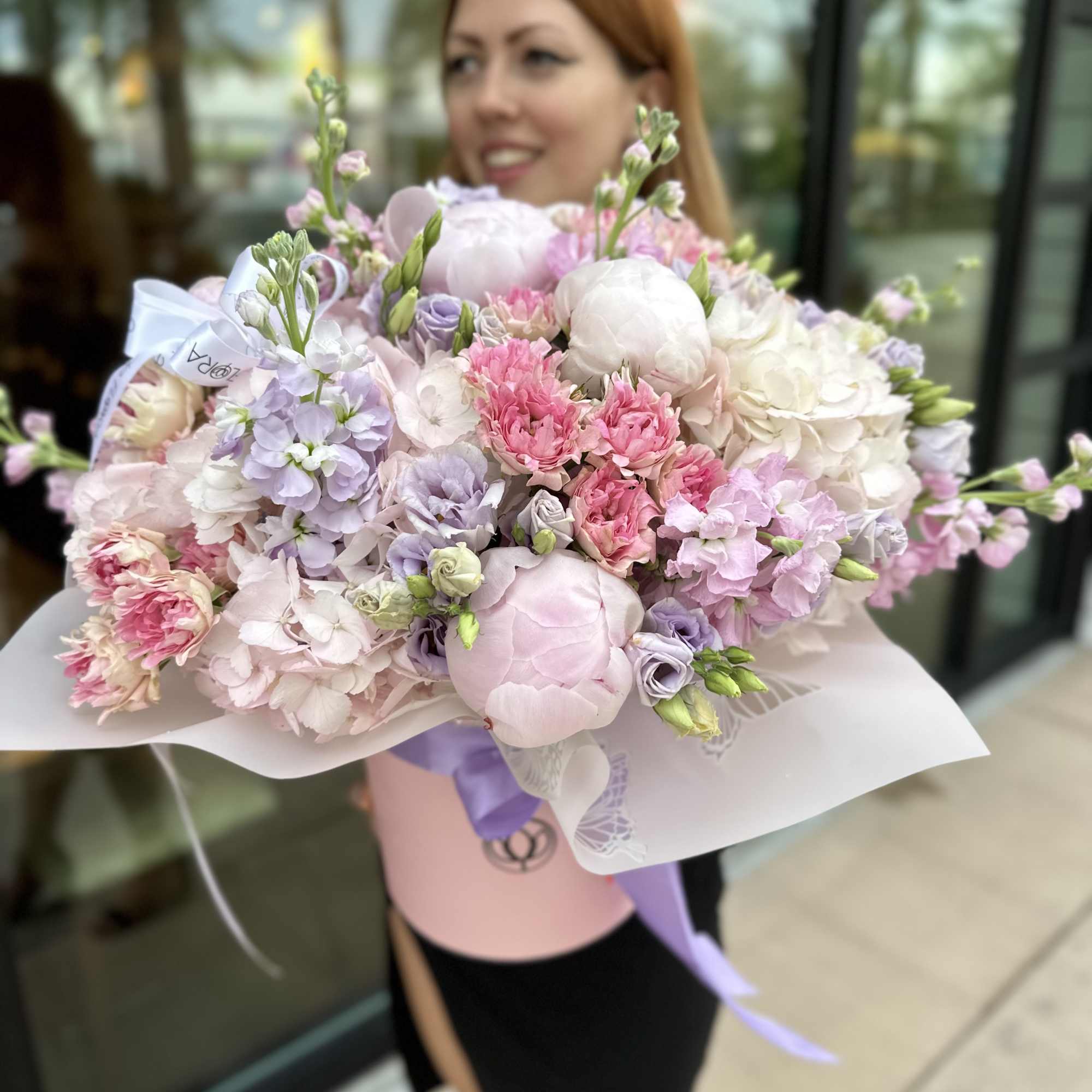Large pastel bouquet of pink, white, and lavender flowers wrapped in paper, photo 5 of 5