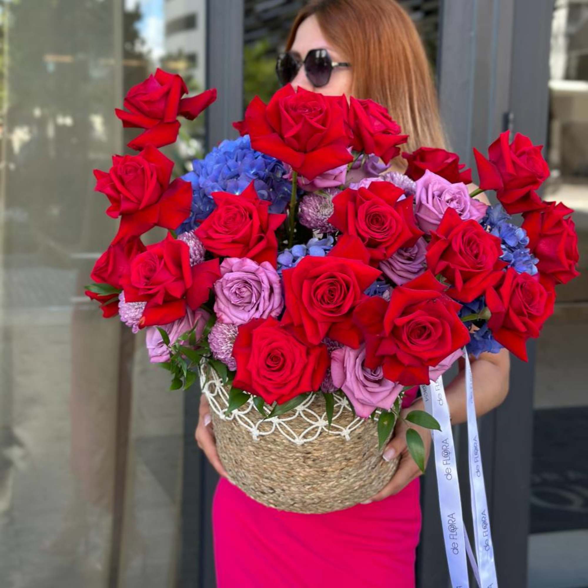 Large bouquet of red and lavender roses in a woven basket