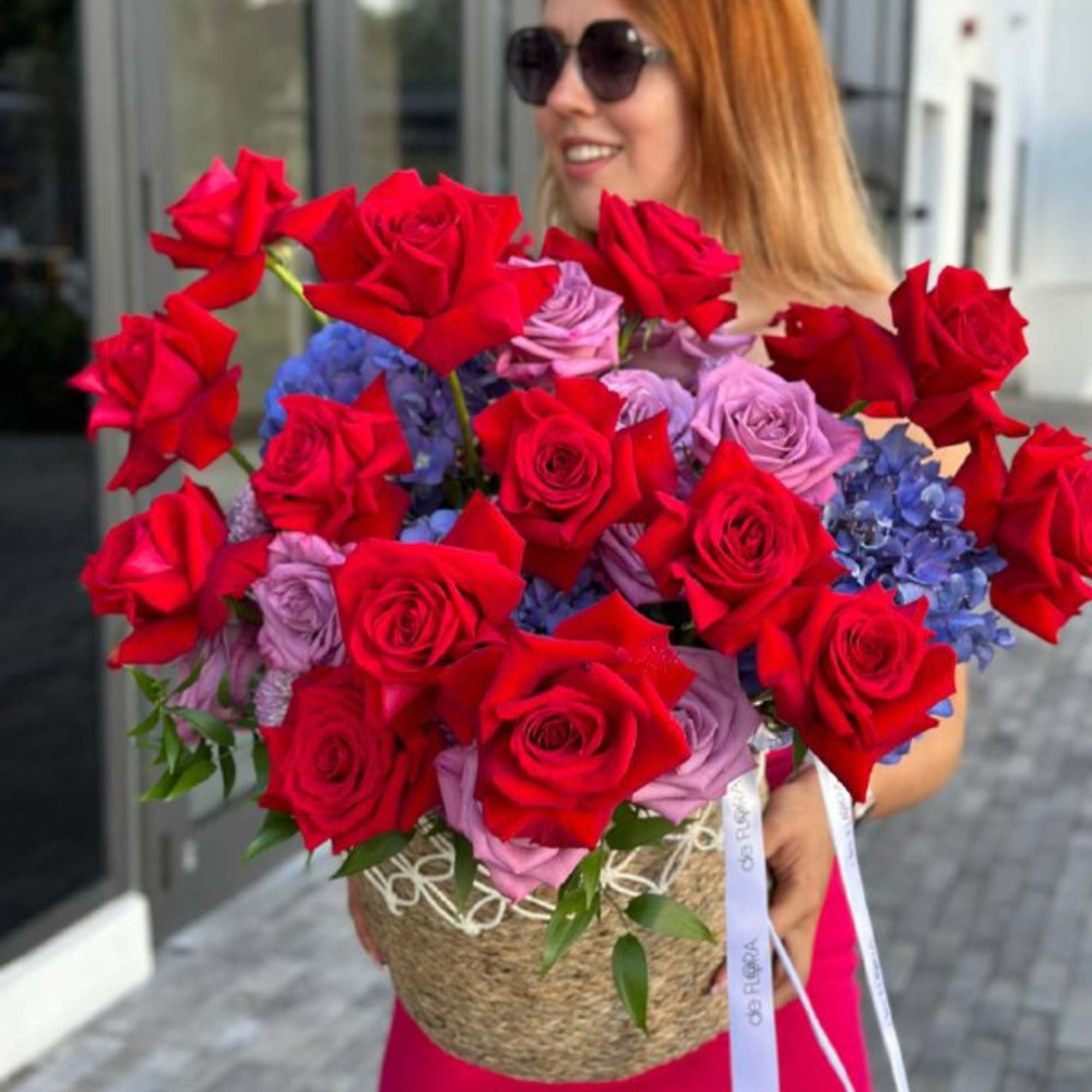 Large bouquet of red and lavender roses with blue hydrangeas in a woven basket, photo 8 of 8