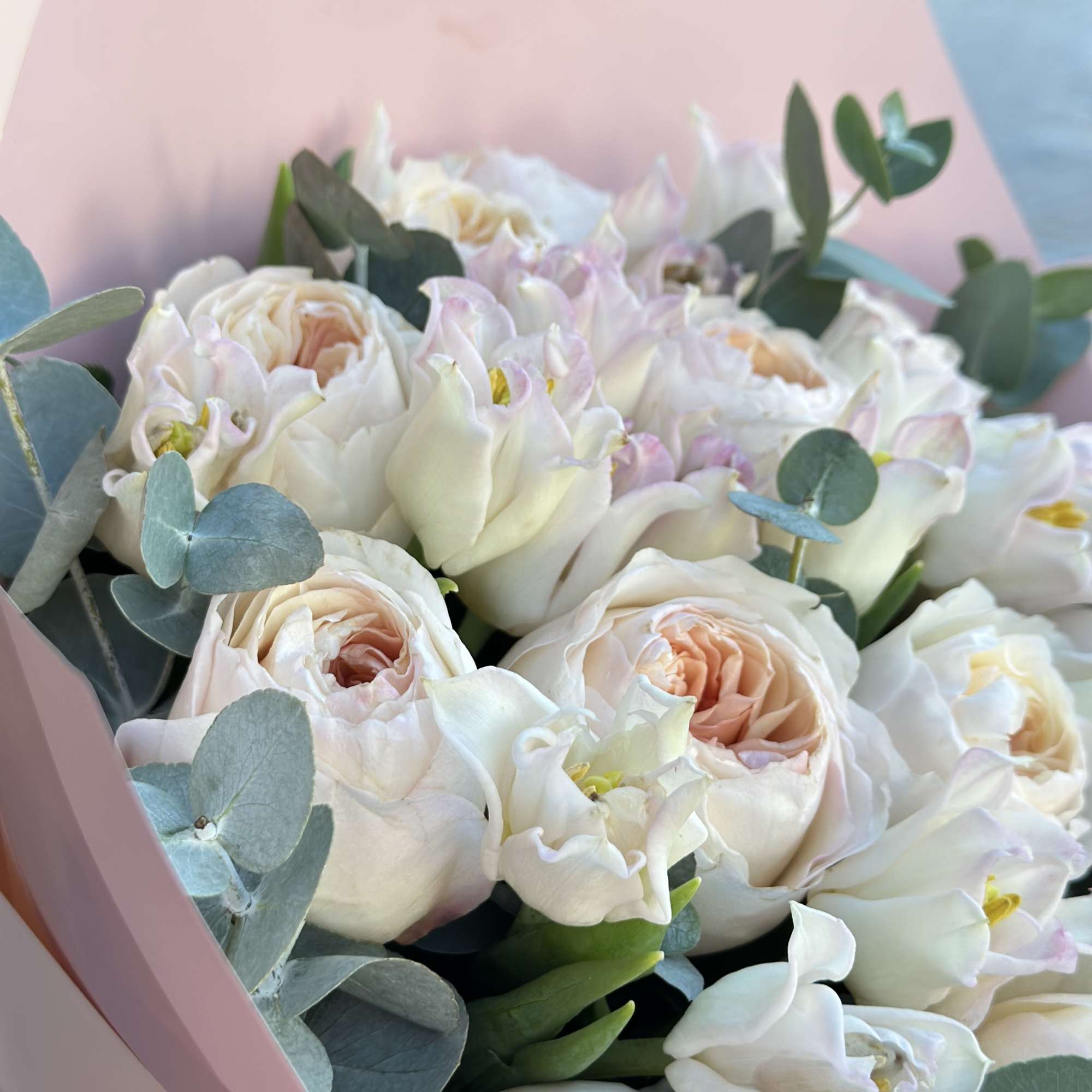 Bouquet of white and blush flowers wrapped in pink paper