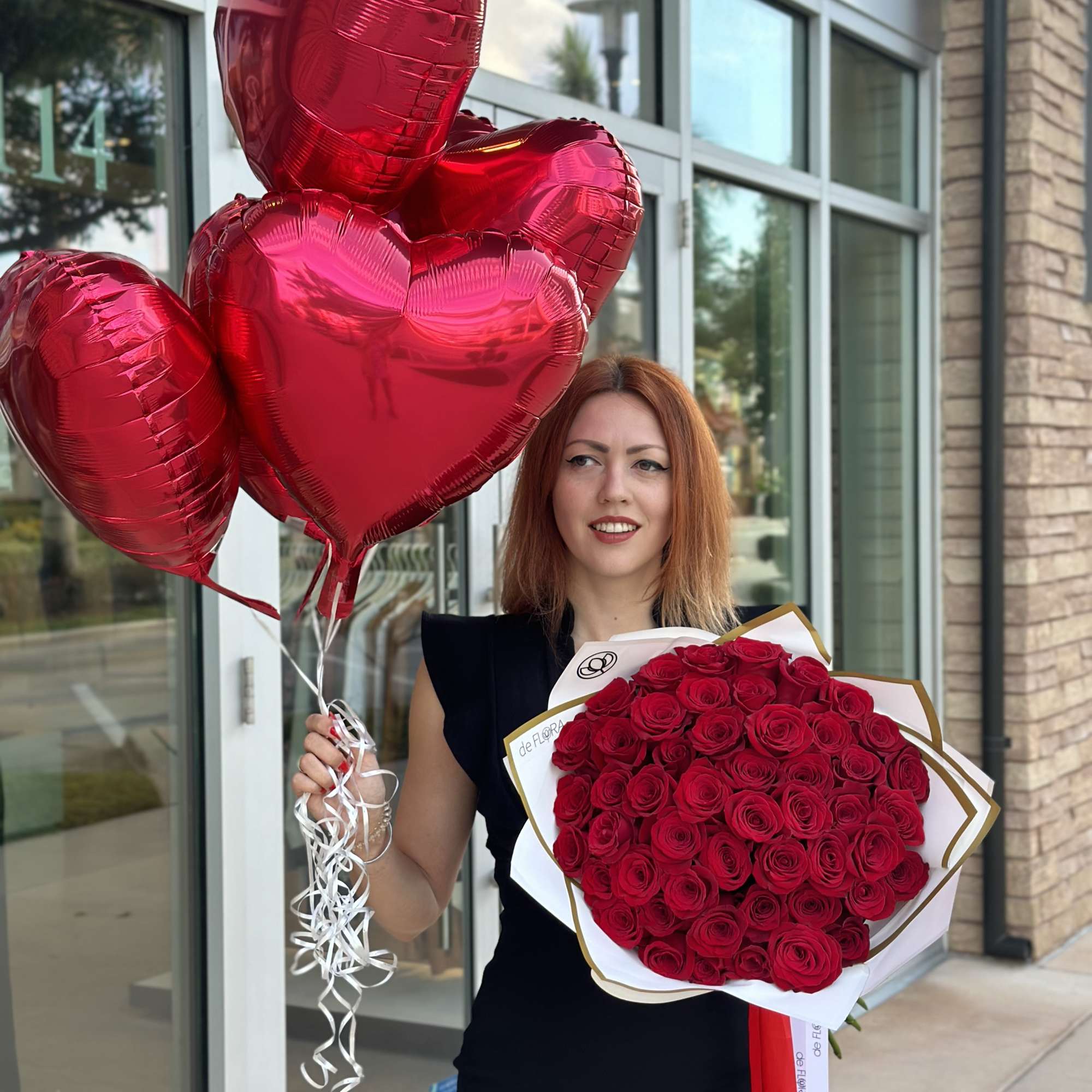 Woman holding red heart balloons and a bouquet of red roses, photo 4 of 7