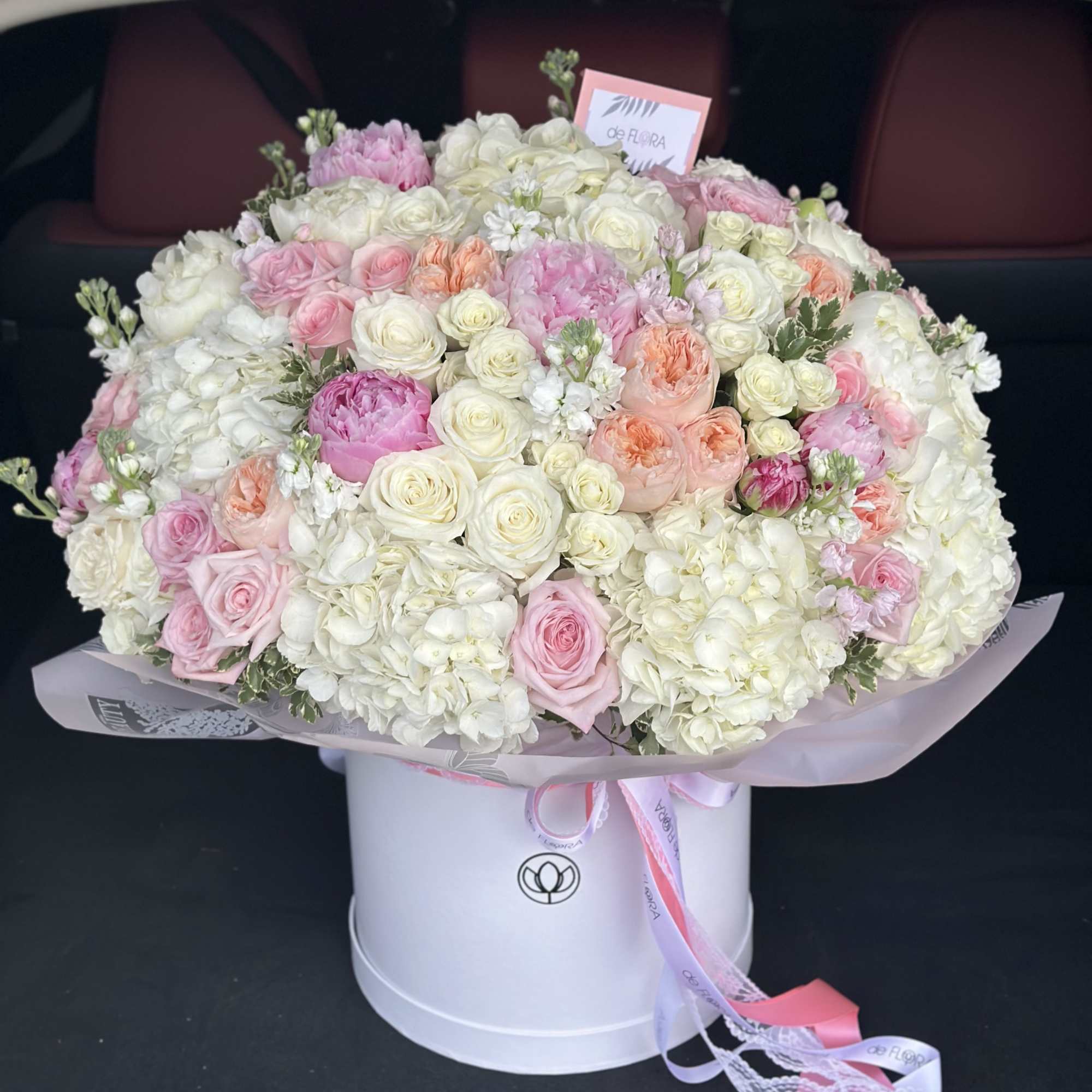 Large bouquet of pink and white roses and hydrangeas in a white hat box