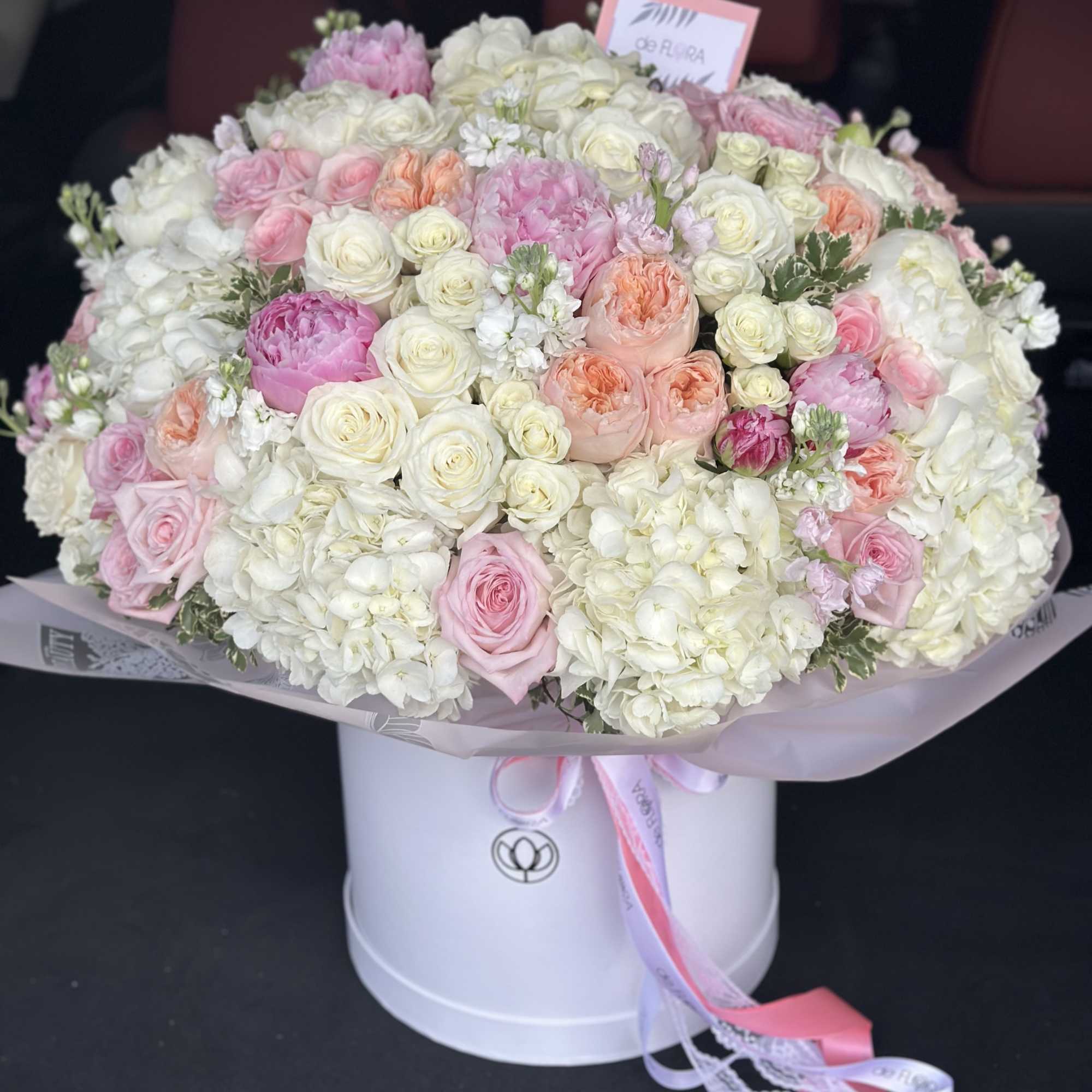Large bouquet of pink and white roses in a white hat box