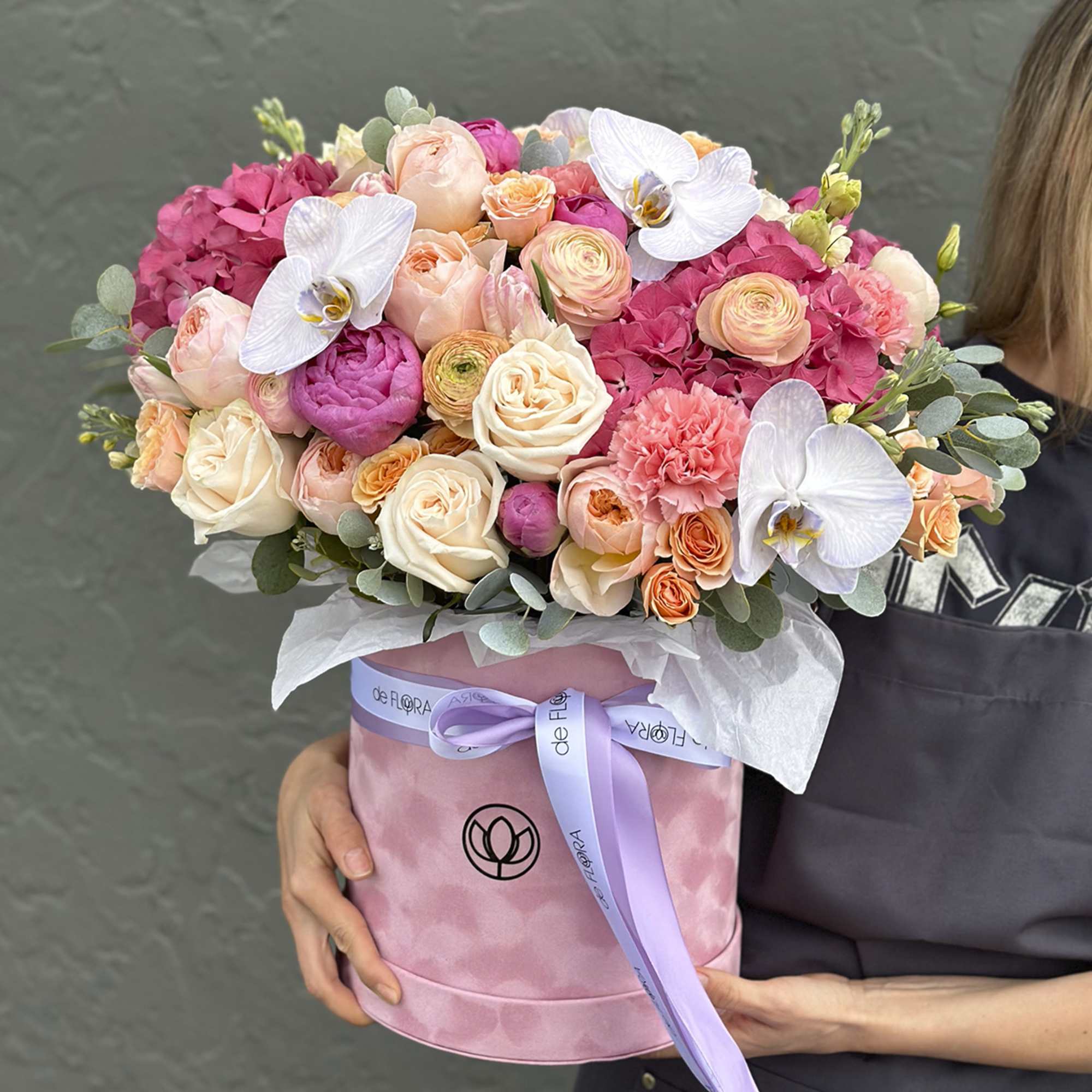 Pink and peach bouquet in a round pink box with white orchids