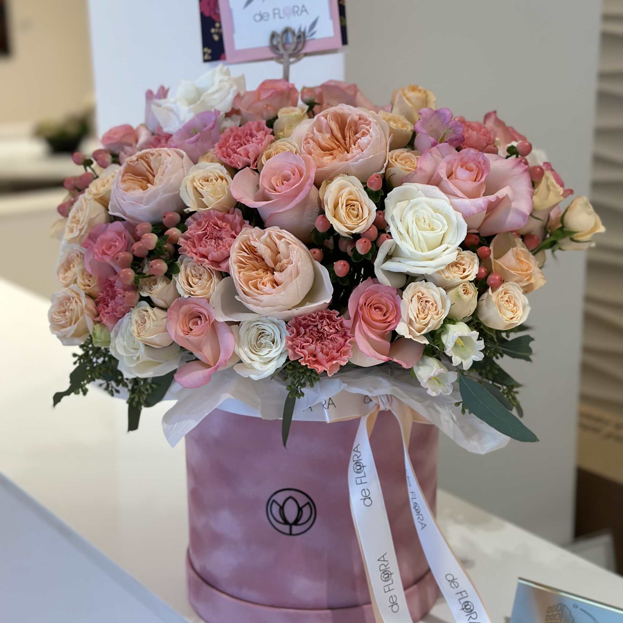 Pink and peach rose bouquet in a pink hat box with ribbon