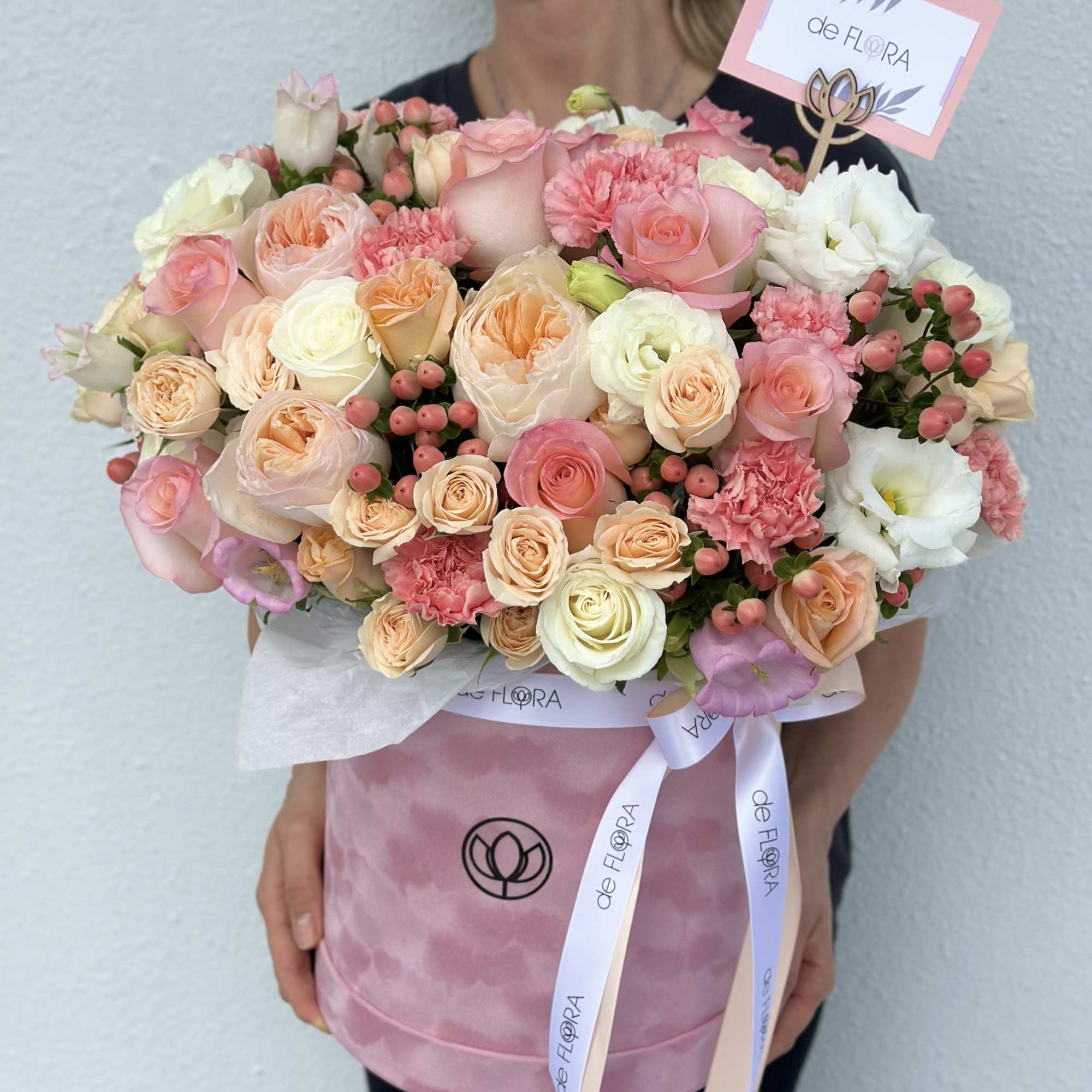 Large bouquet of pink and cream roses in a pink hat box