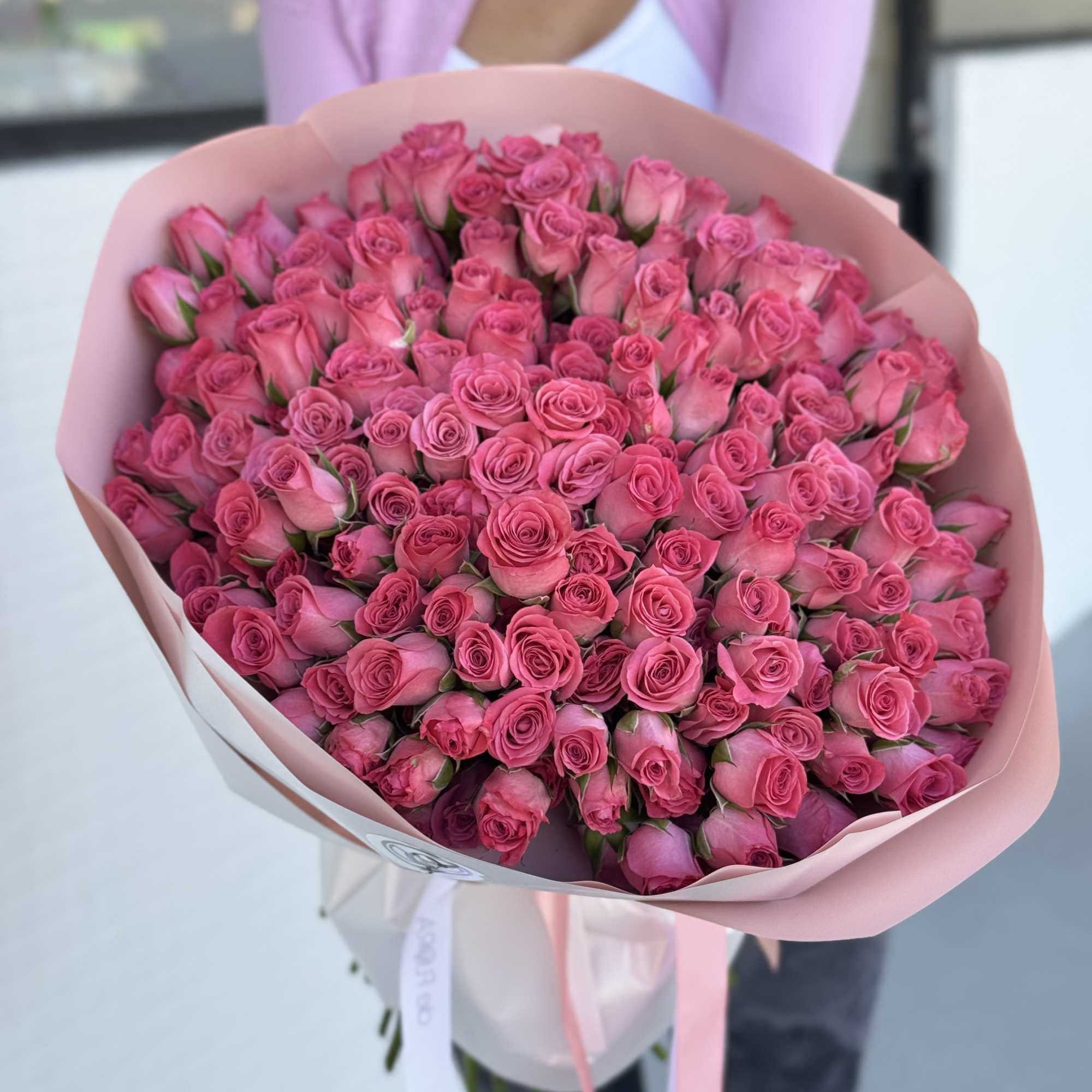 Large bouquet of pink roses wrapped in pale pink paper
