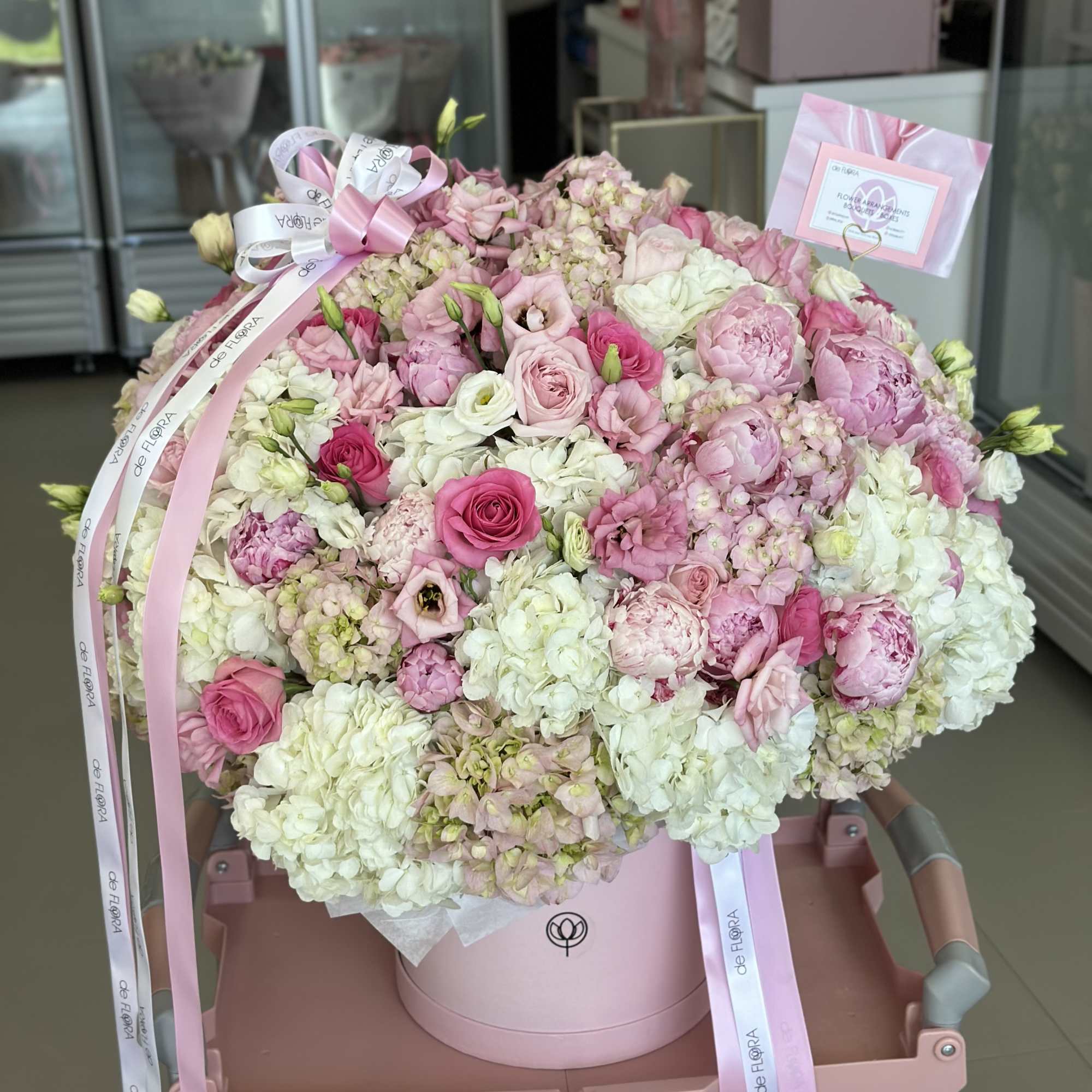 Large pink and white bouquet in a round box with ribbons