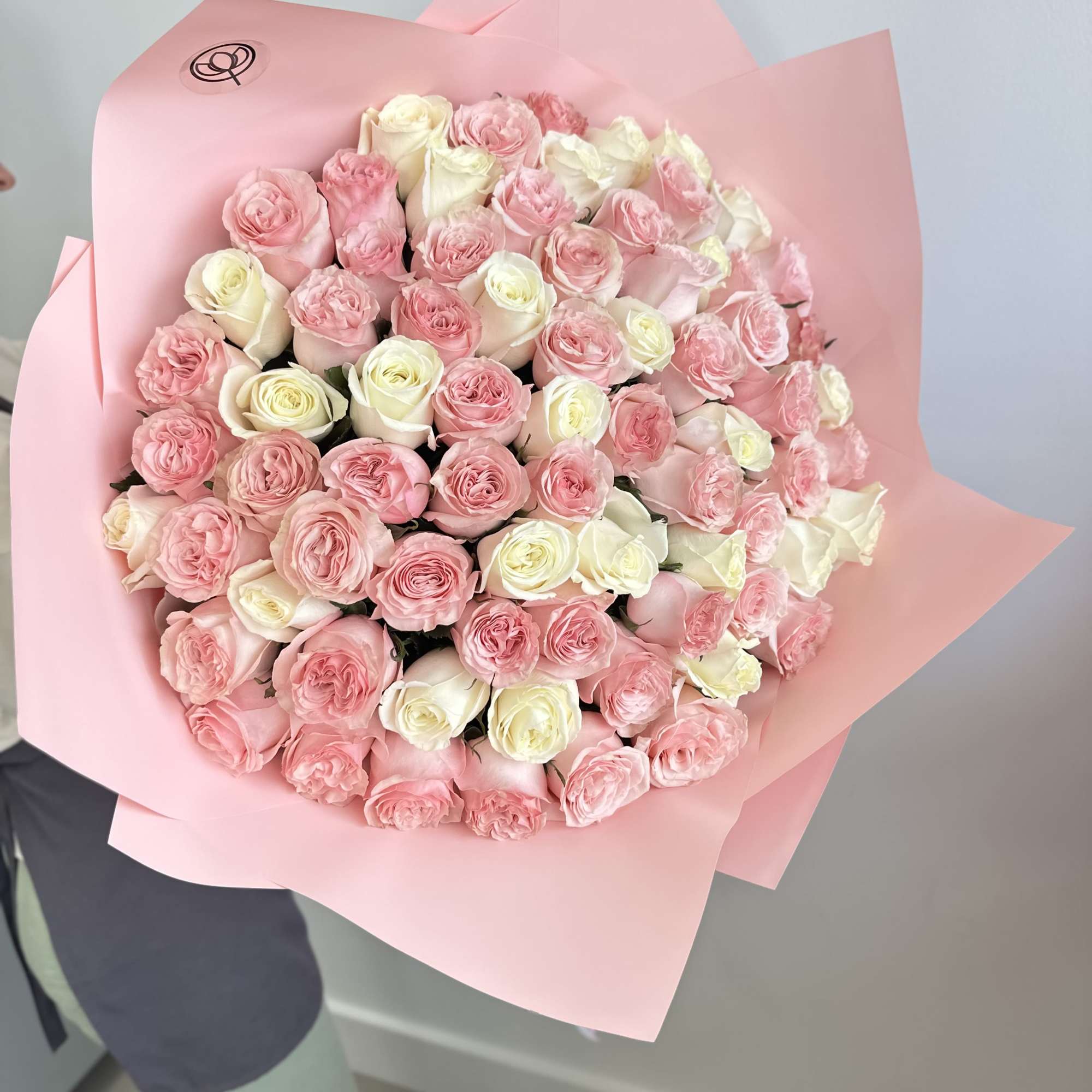 Large bouquet of pink and white roses wrapped in pink paper