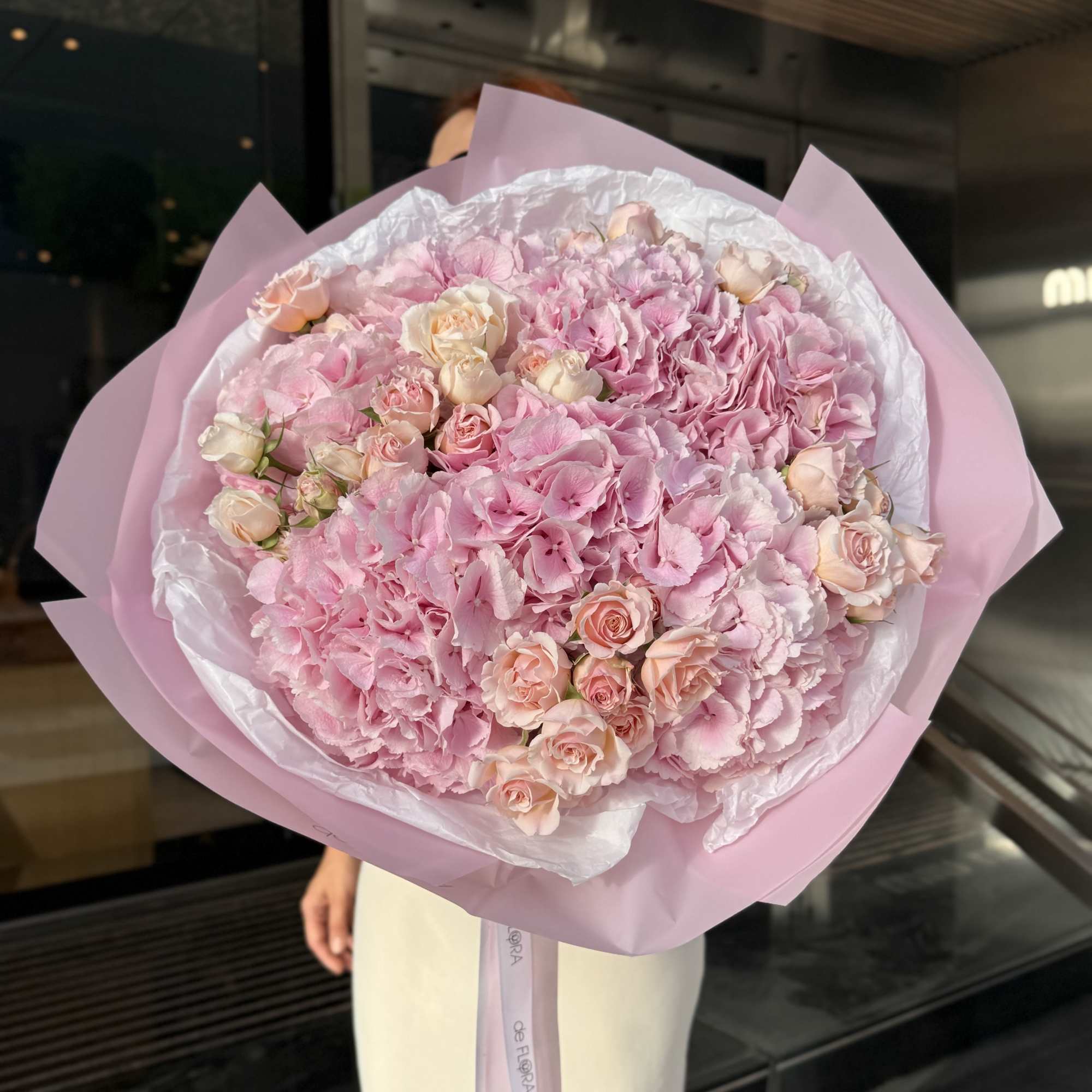 Large pink bouquet of hydrangeas and small roses wrapped in pastel paper, photo 3 of 4