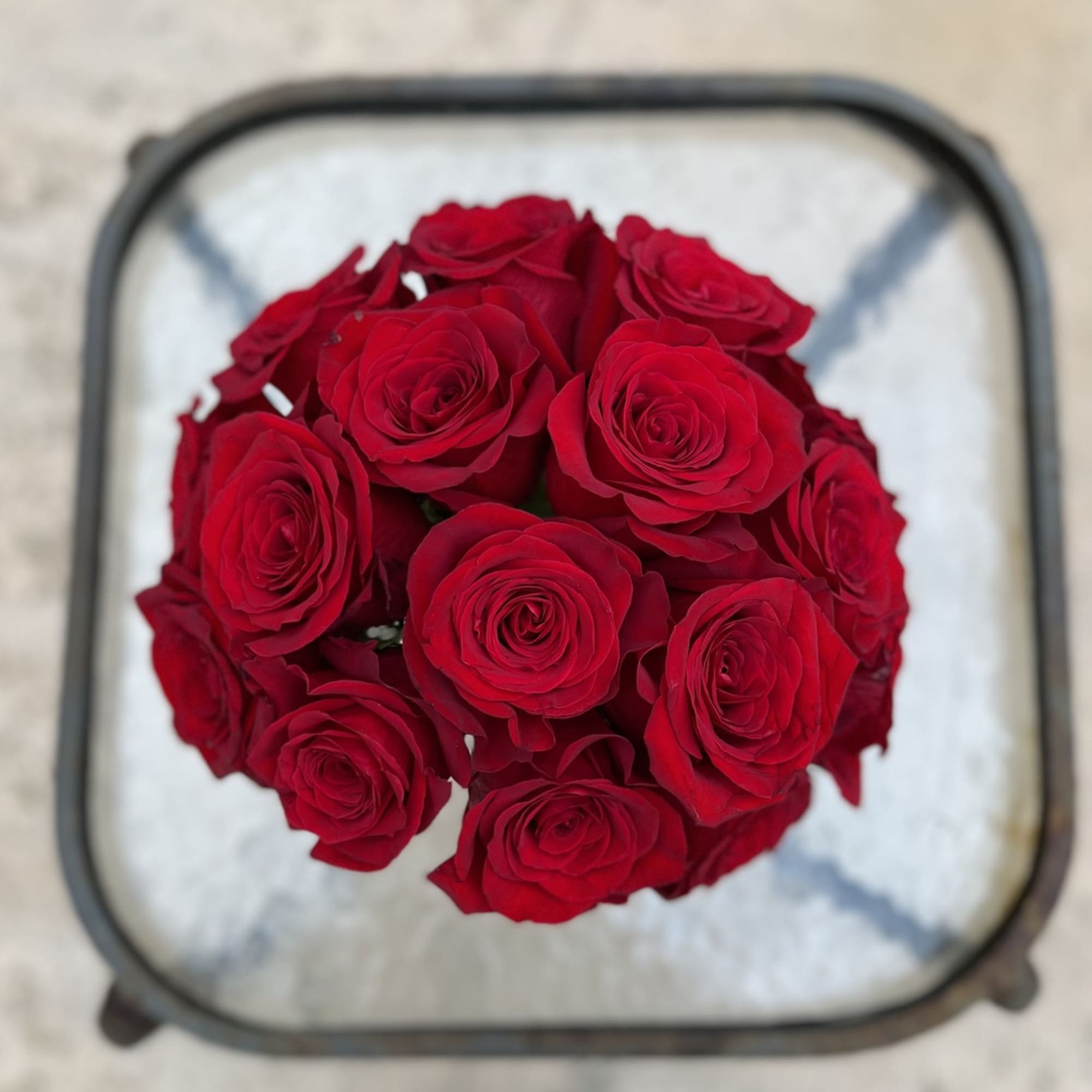 Top view of a bouquet of red roses in a square container