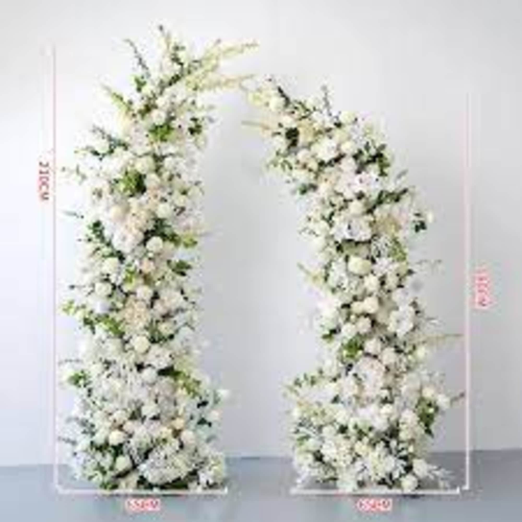 Tall asymmetrical white floral pillars forming an open wedding arch.