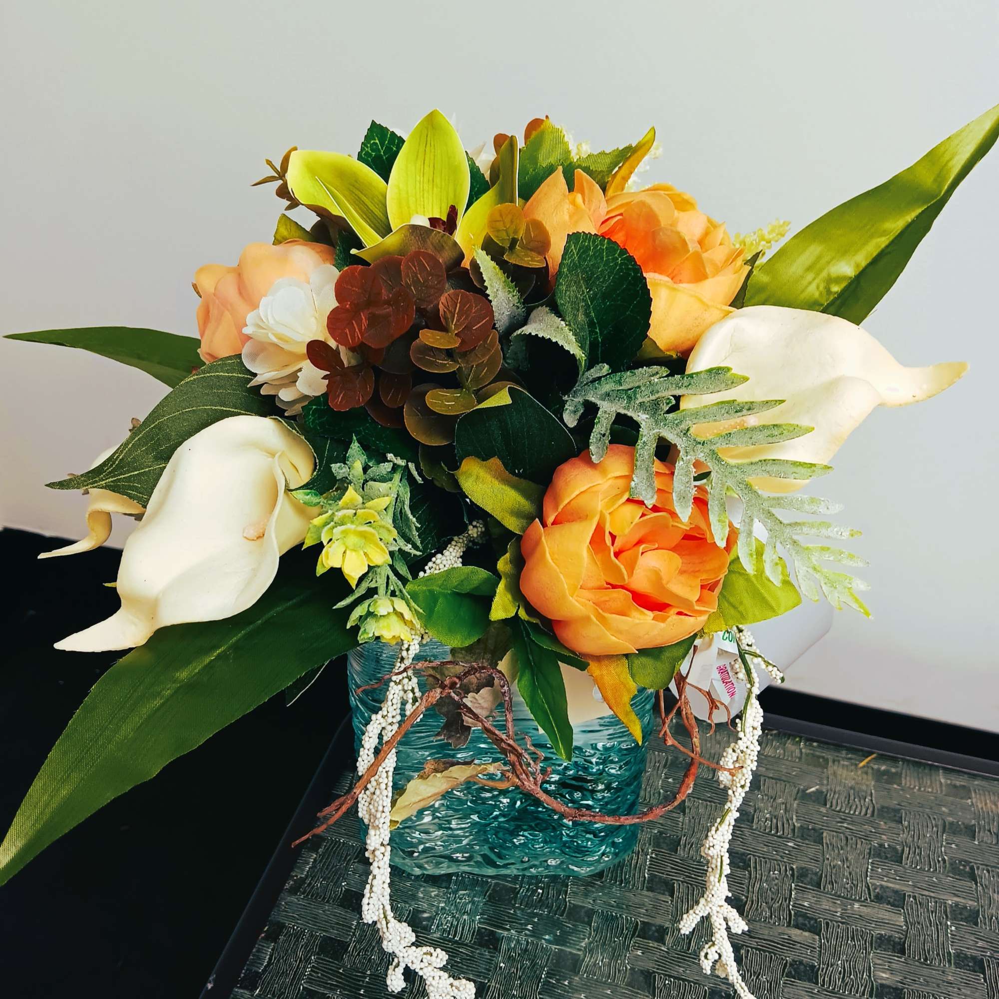 Bouquet of orange and white flowers in a blue glass vase