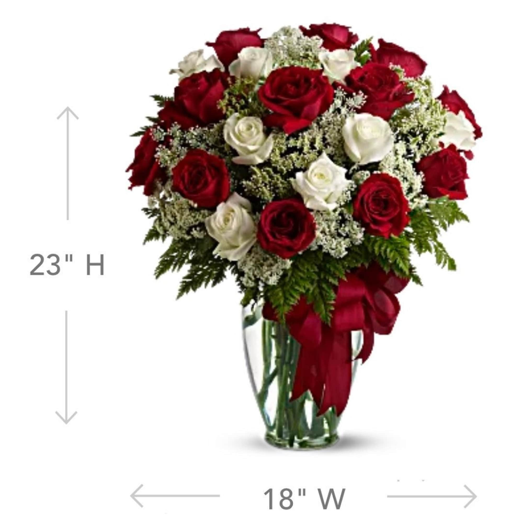 Red and white roses arranged in a clear glass vase with a red ribbon, photo 4 of 5
