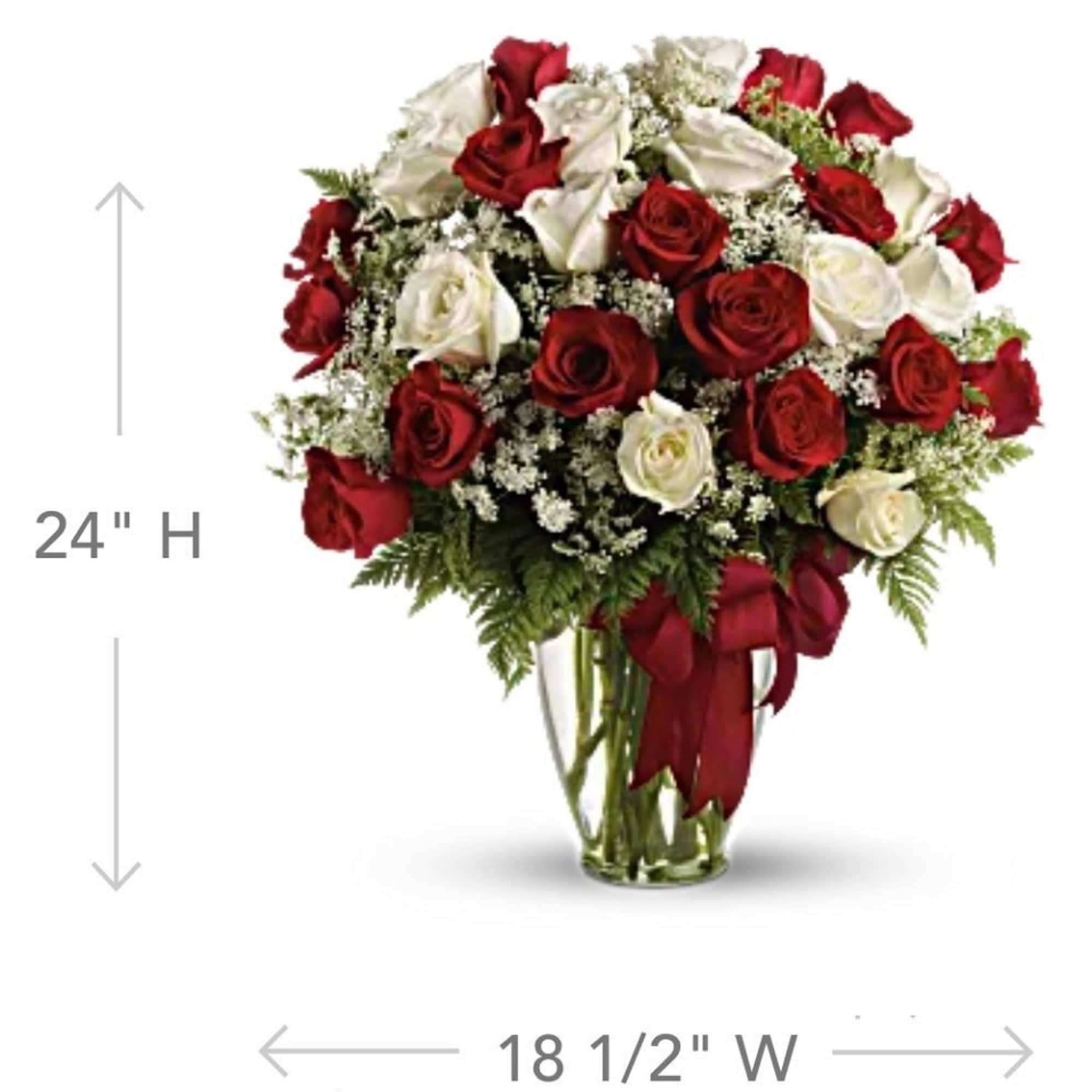 Red and white roses arranged in a clear glass vase