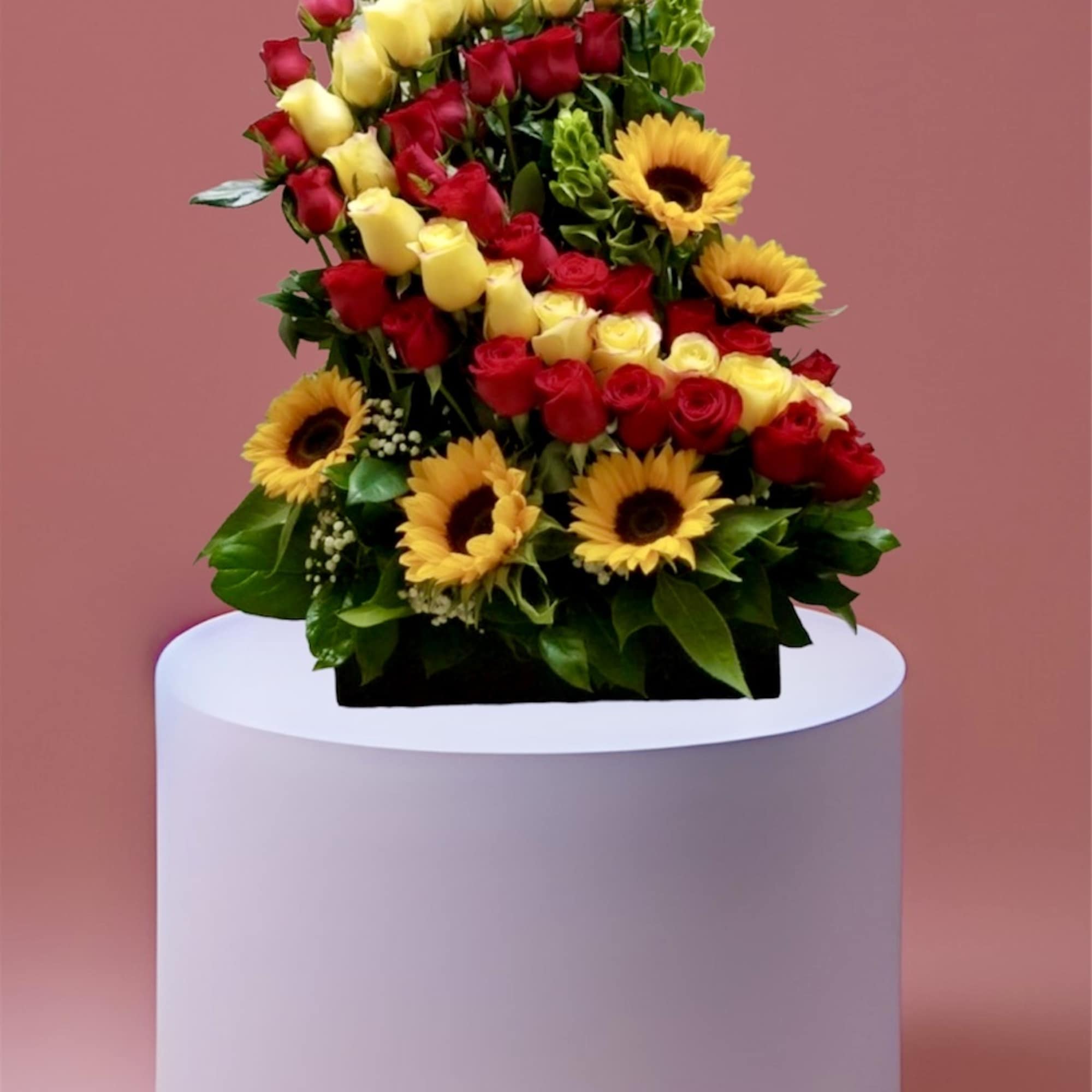 Tiered bouquet of red and yellow roses with sunflowers on a pedestal