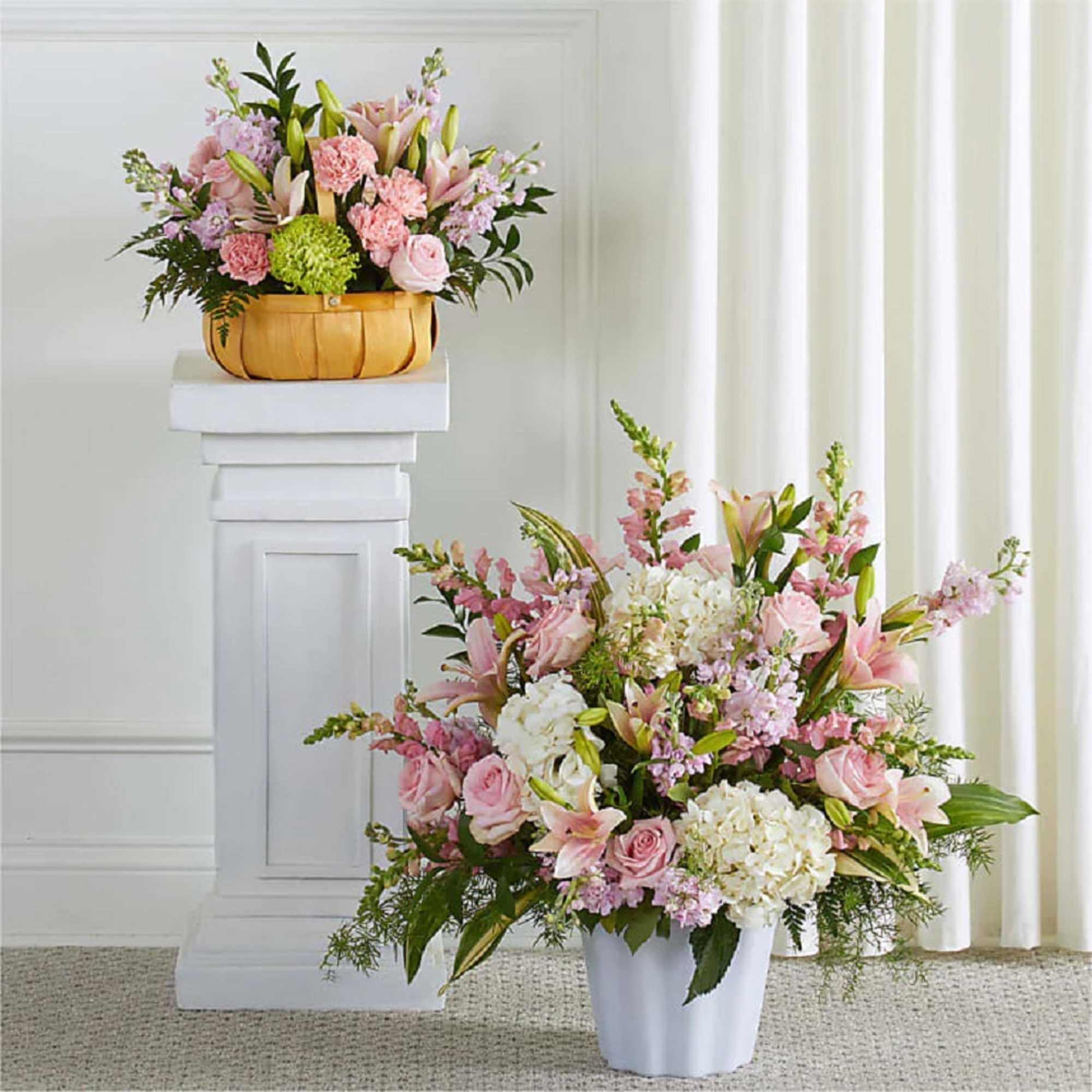 Pink and white floral arrangements in a basket and white vase