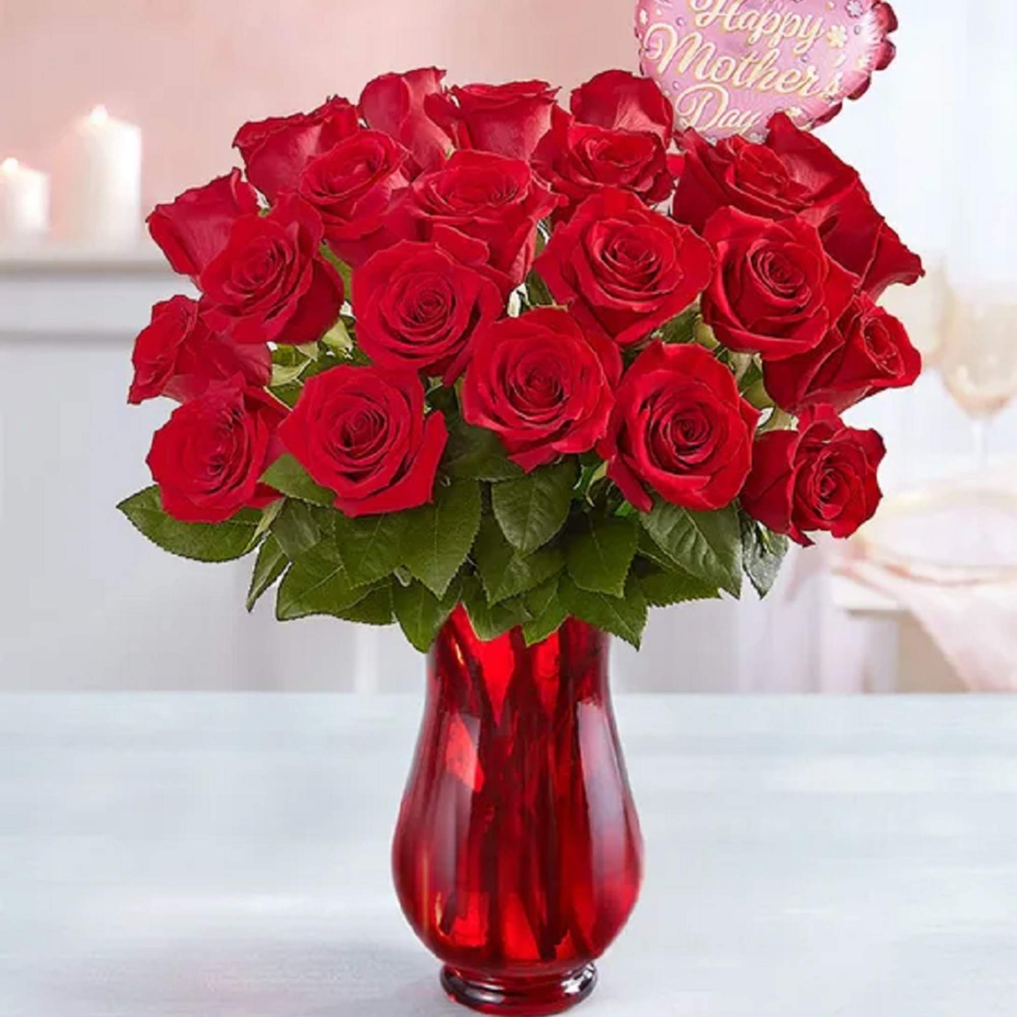 Red roses in a red glass vase with a Happy Mother's Day balloon