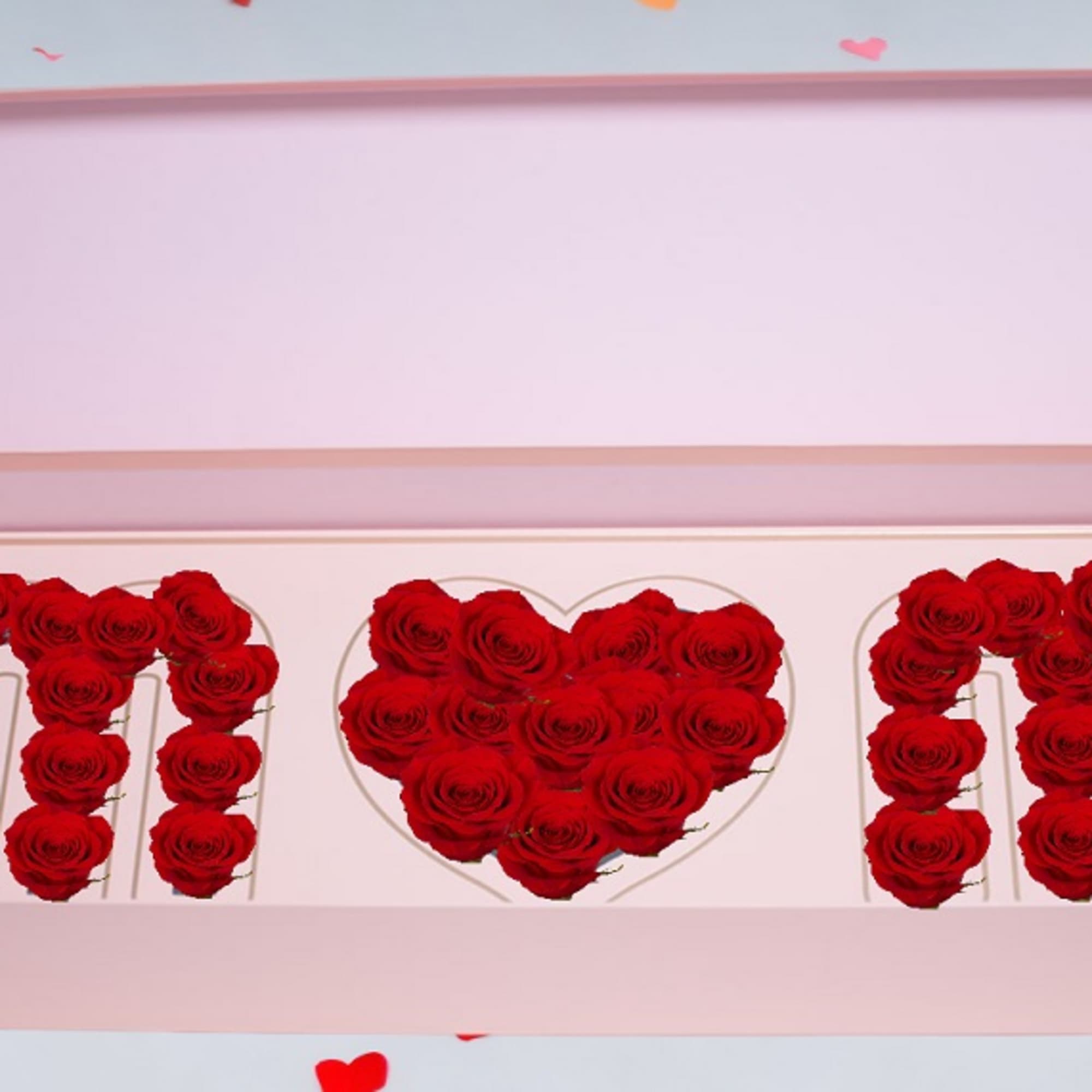 Red roses arranged in a pink gift box with heart shapes