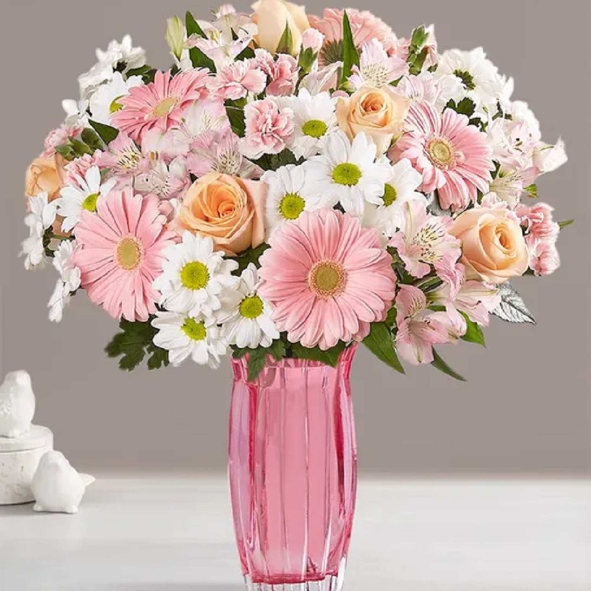 Pink and white mixed bouquet in a pink glass vase