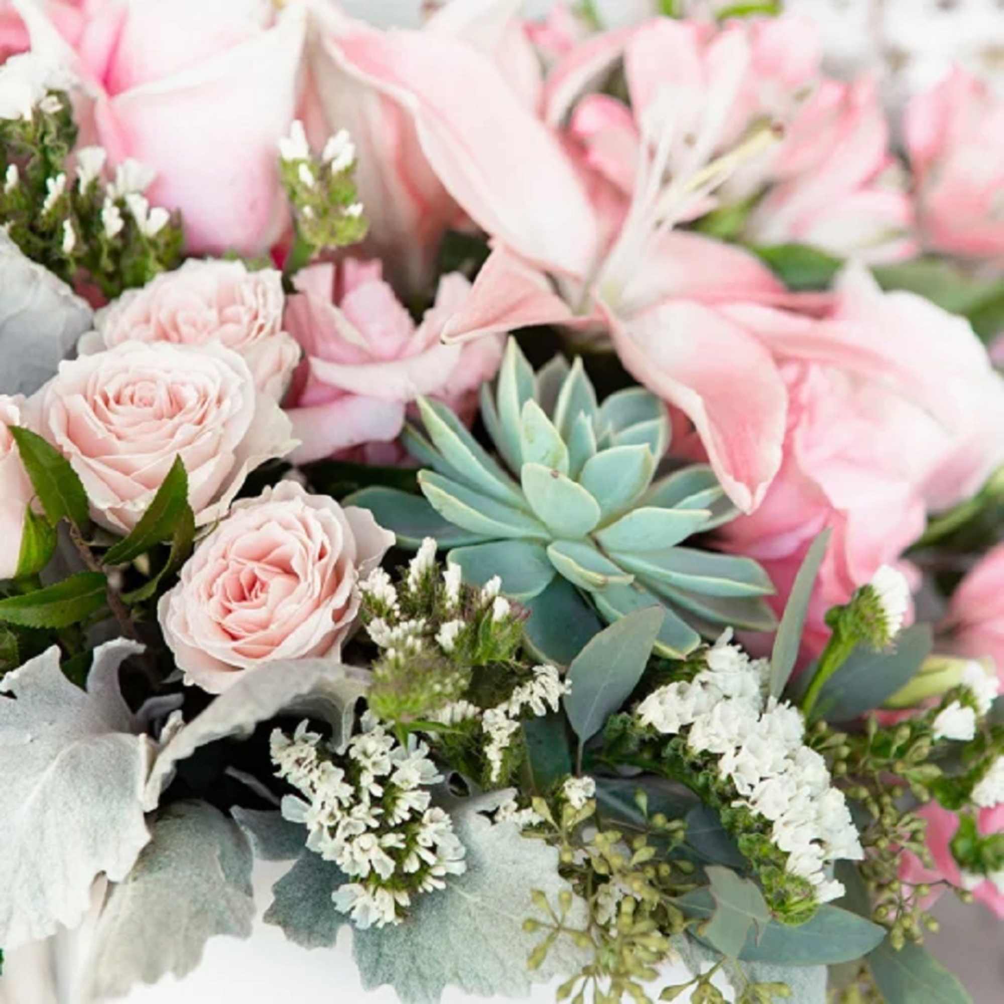 Pink roses and lilies with a teal succulent and white filler flowers