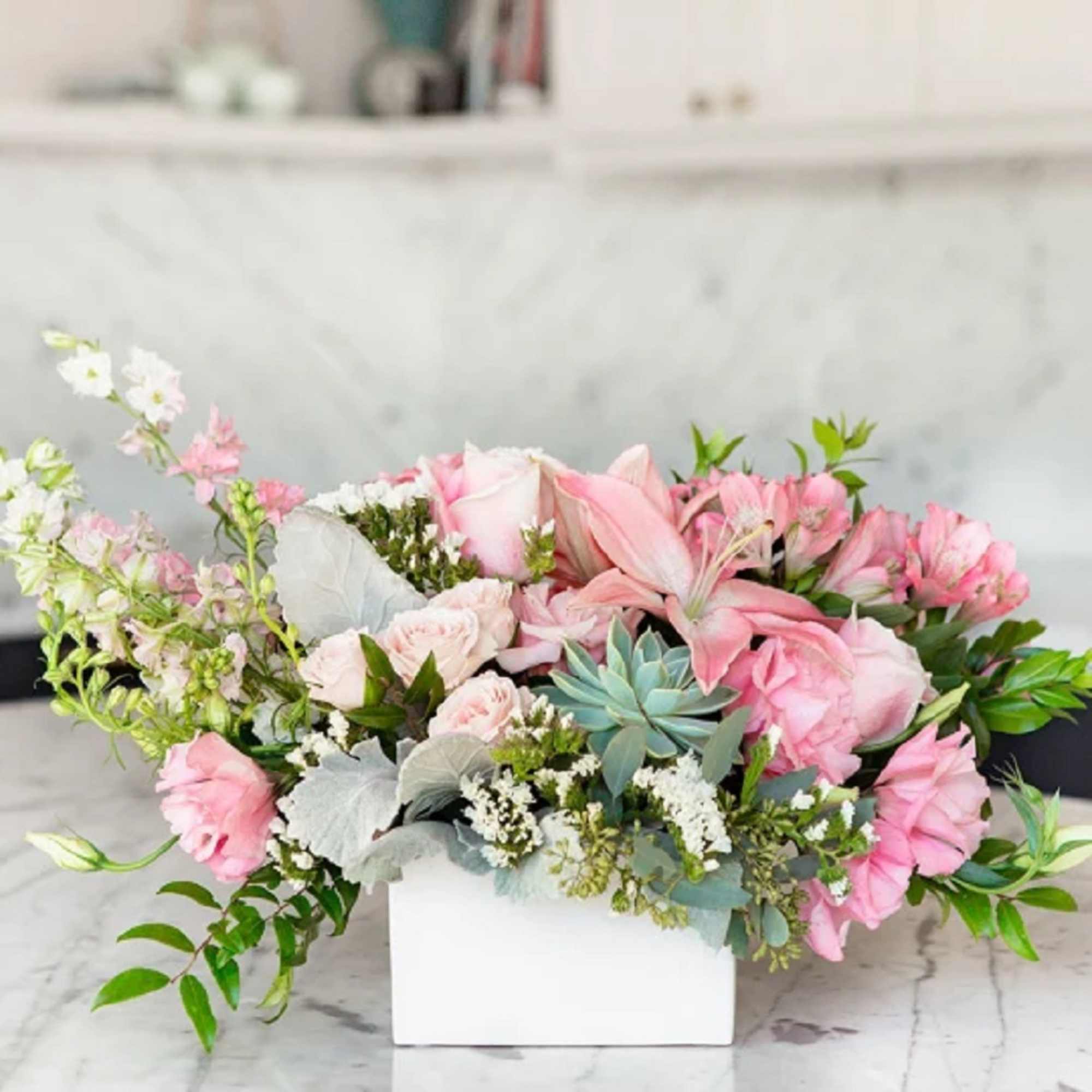 Pink and white floral arrangement in a white rectangular box