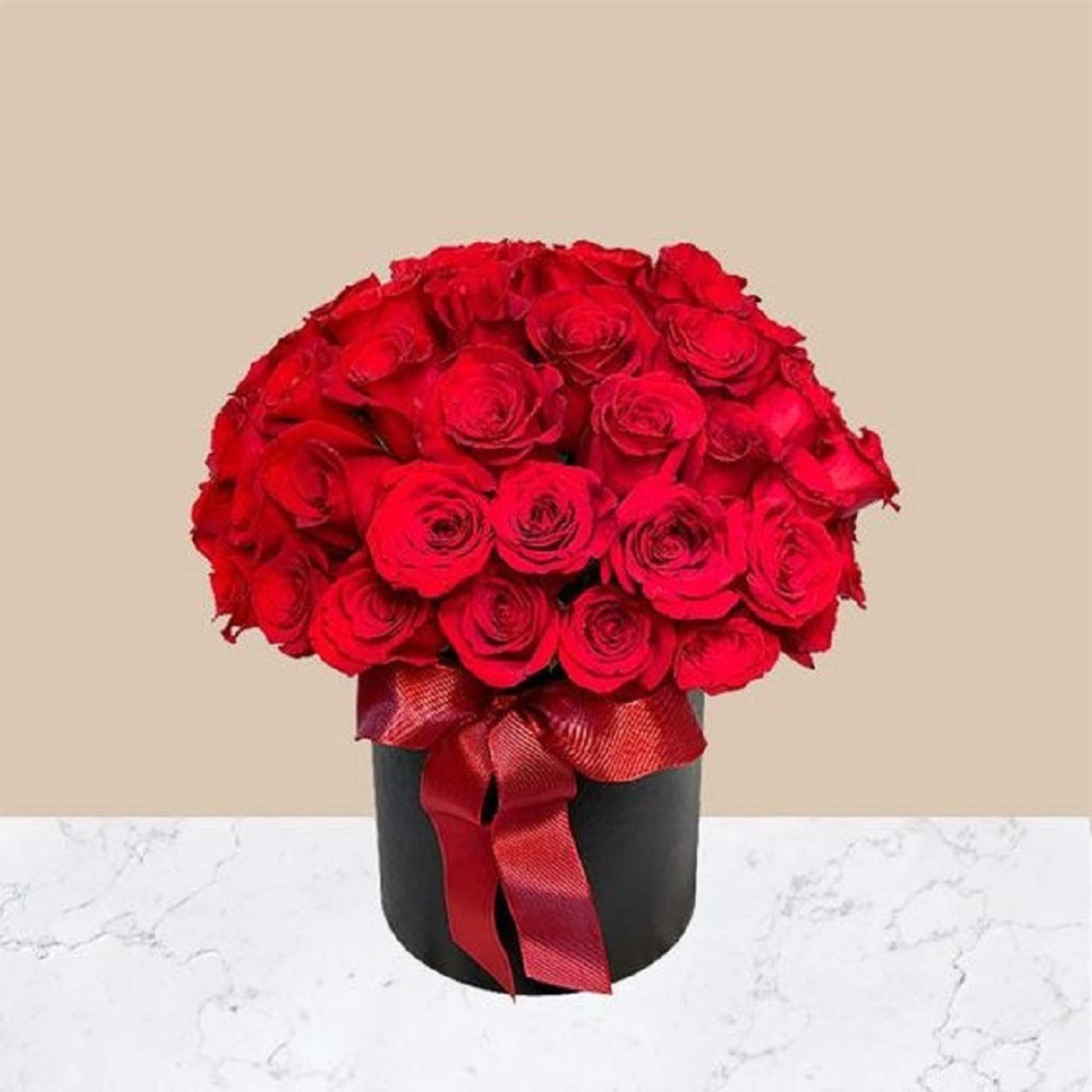 Bouquet of red roses in a black box with a red ribbon