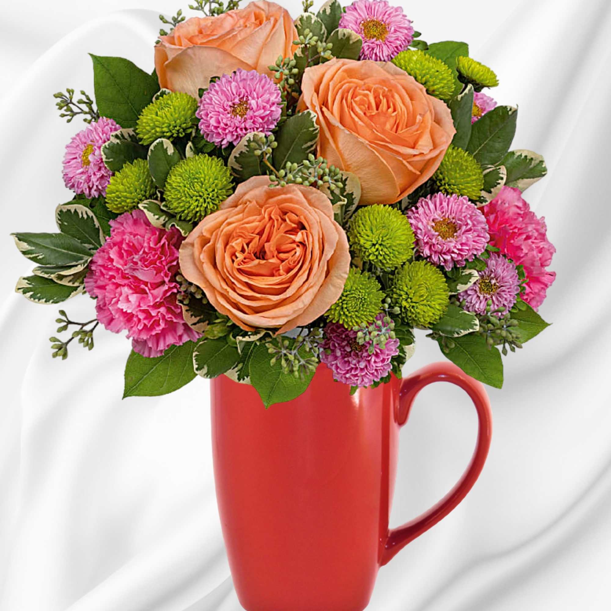 Peach and pink flower bouquet in a red mug vase