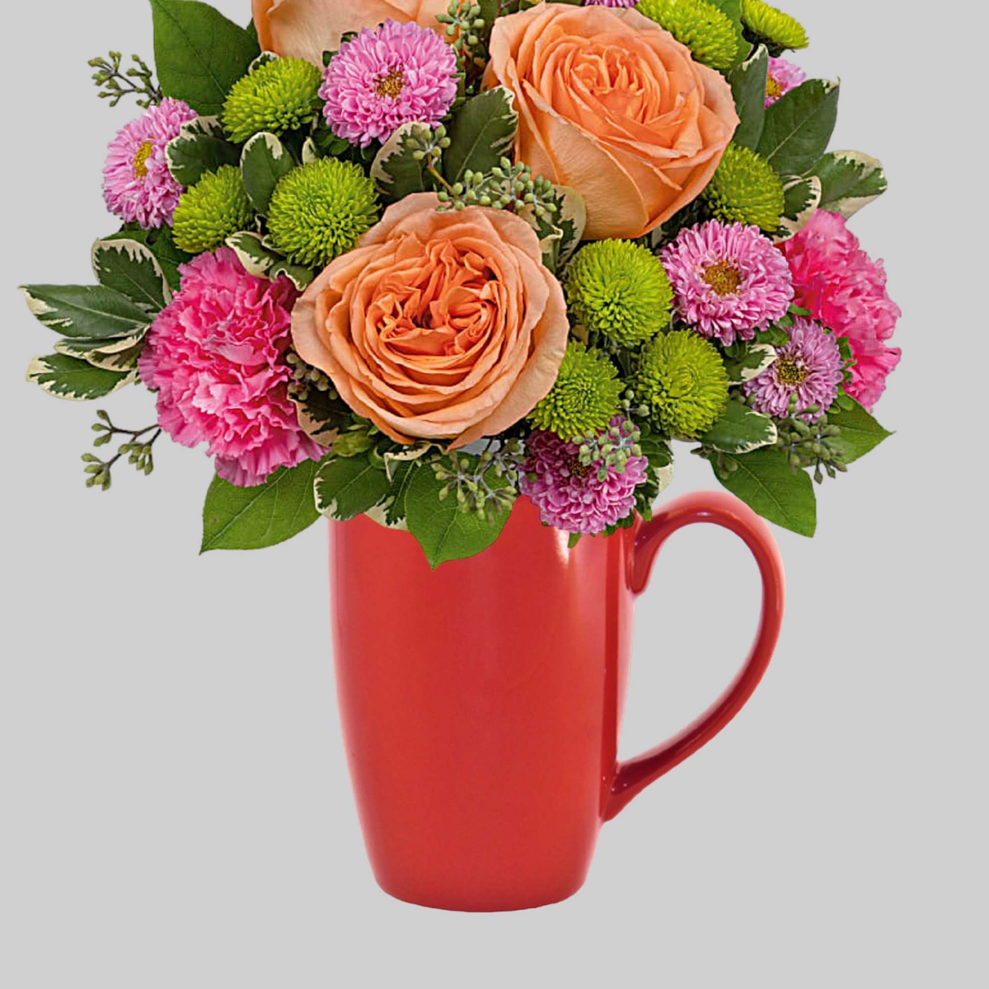 Peach roses and pink flowers arranged in a red mug vase