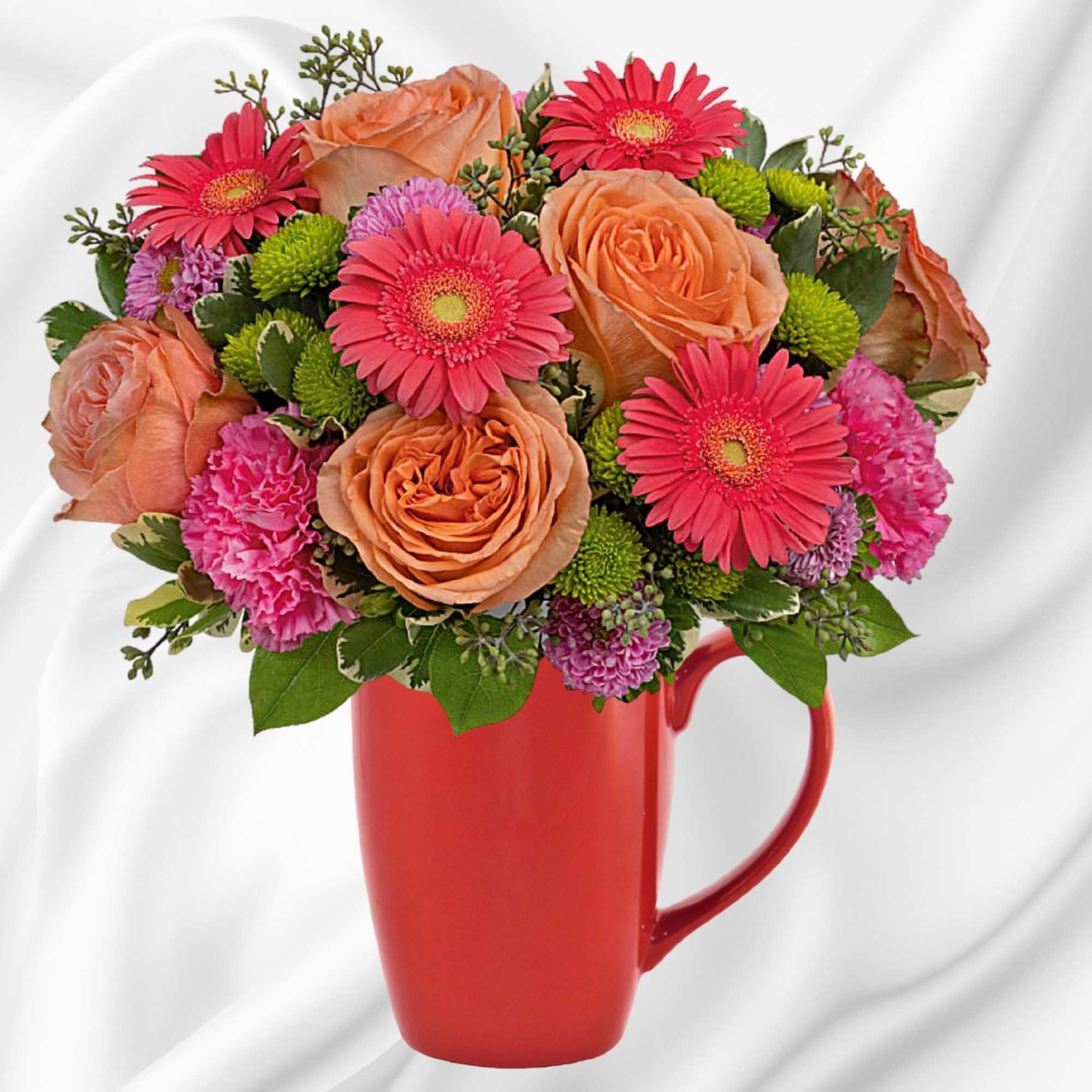 Bouquet of orange roses, pink gerbera daisies, and carnations in a red mug vase