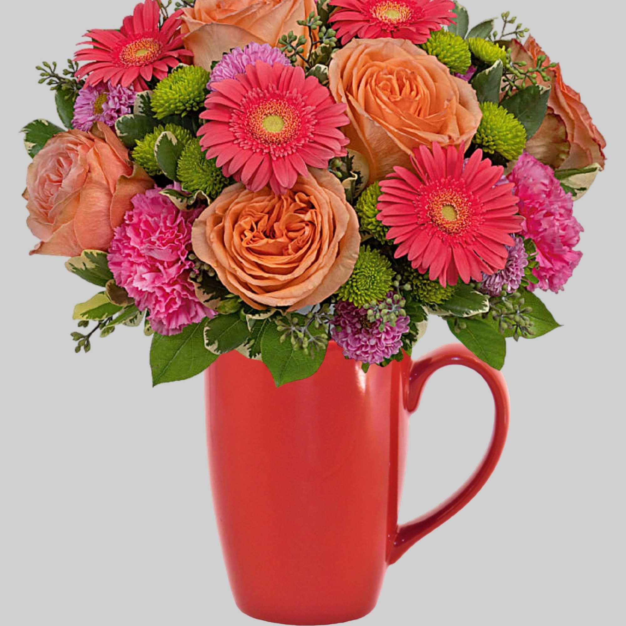 Bouquet of pink gerbera daisies, peach roses, and carnations in a red mug vase
