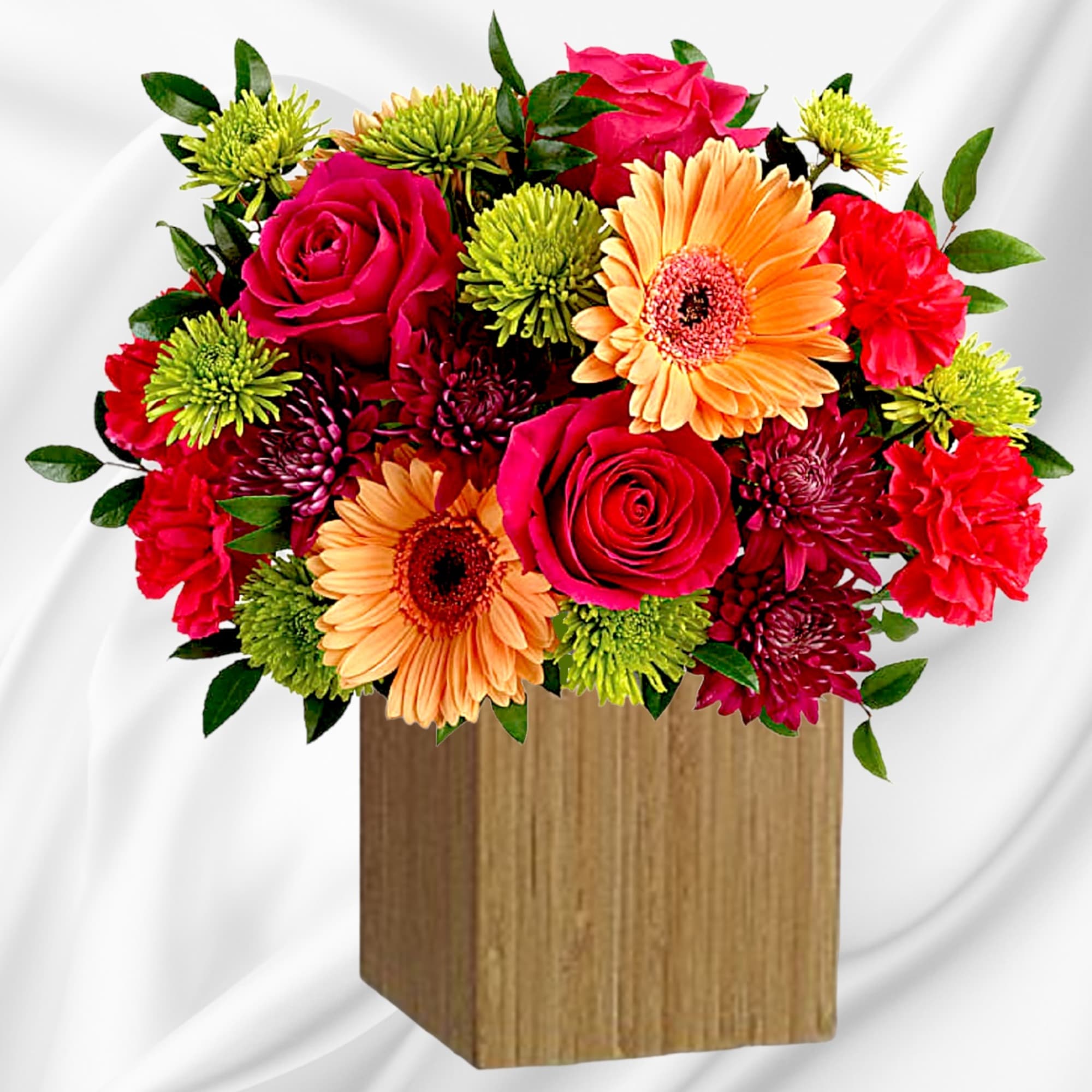 Bright mixed bouquet in a wooden cube vase with roses, gerbera daisies, and mums