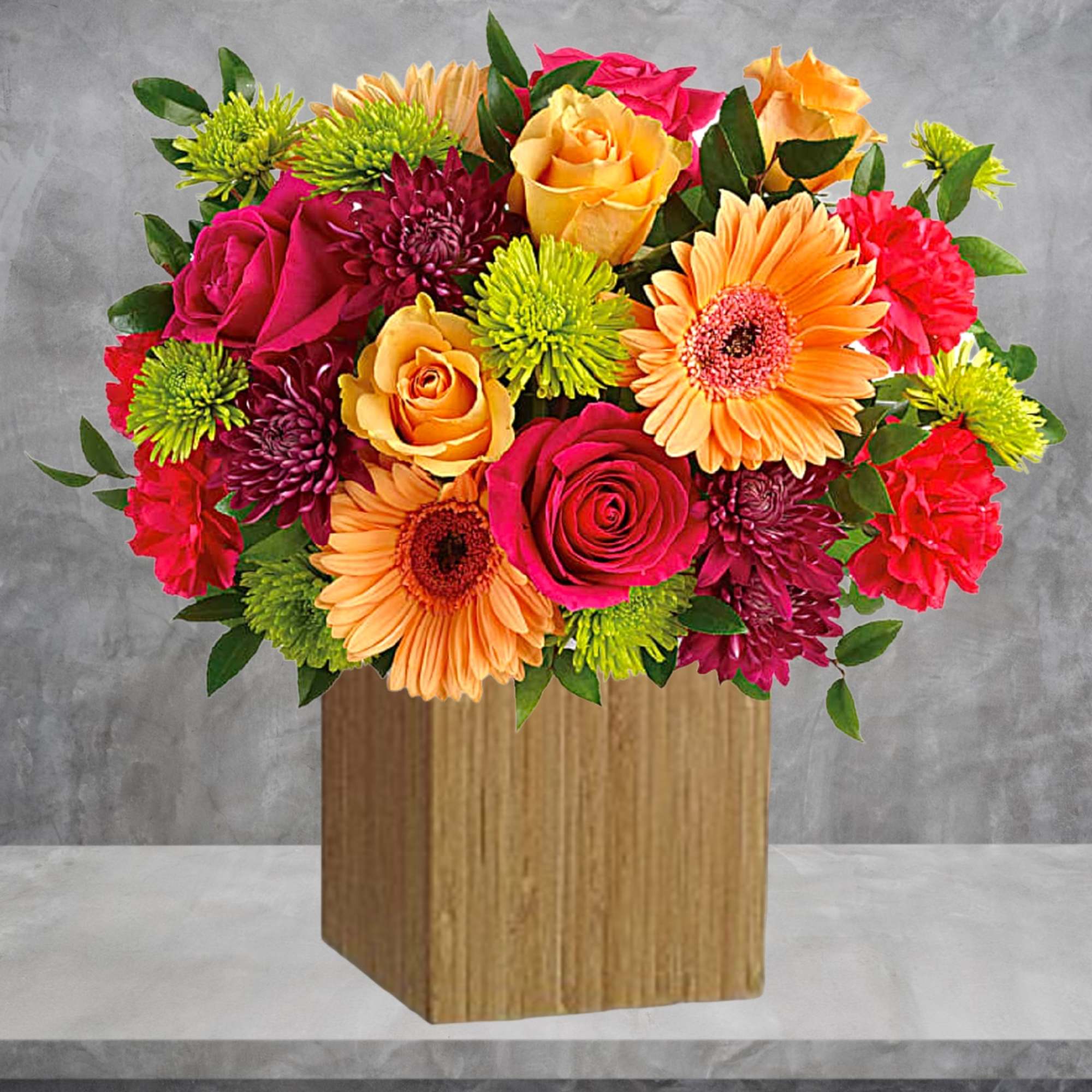 Colorful bouquet of roses, gerbera daisies, and chrysanthemums in a wooden vase