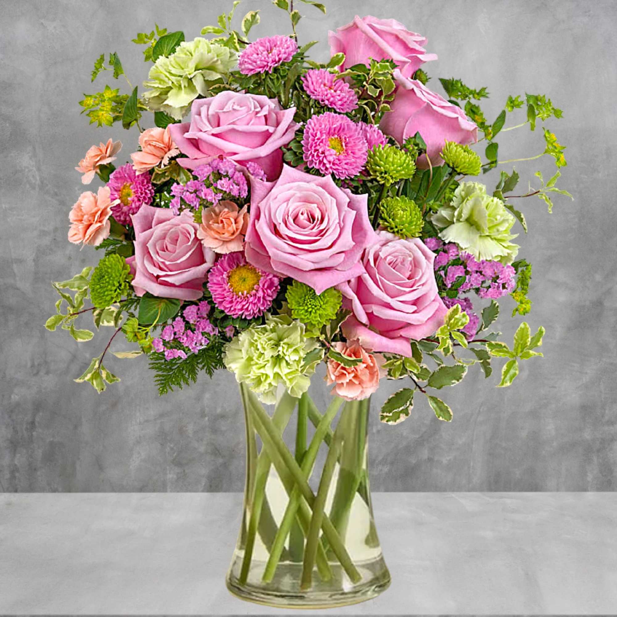 Pink roses and mixed flowers arranged in a clear glass vase, photo 3 of 4
