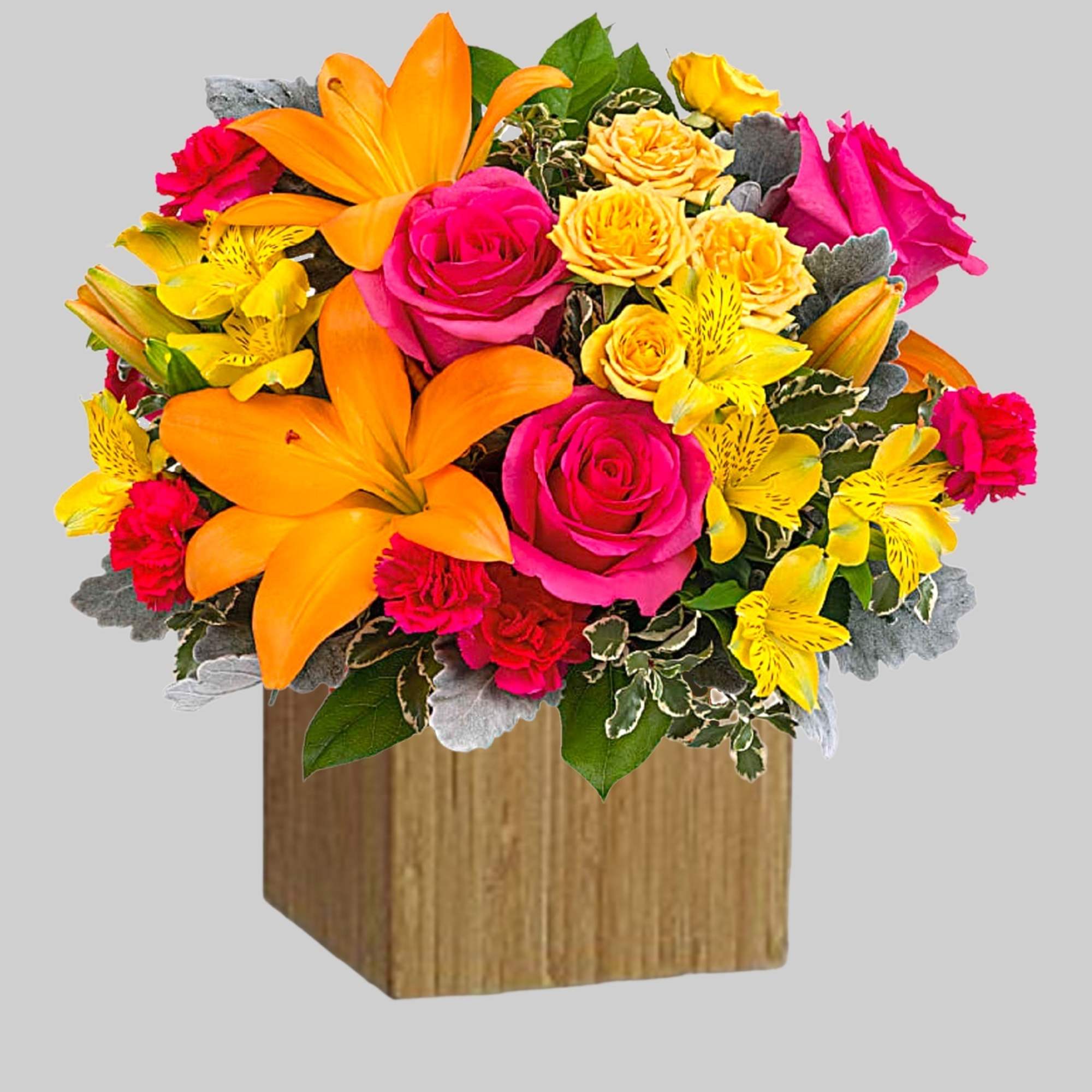 Bright bouquet of orange lilies, pink roses, and yellow flowers in a wooden cube vase