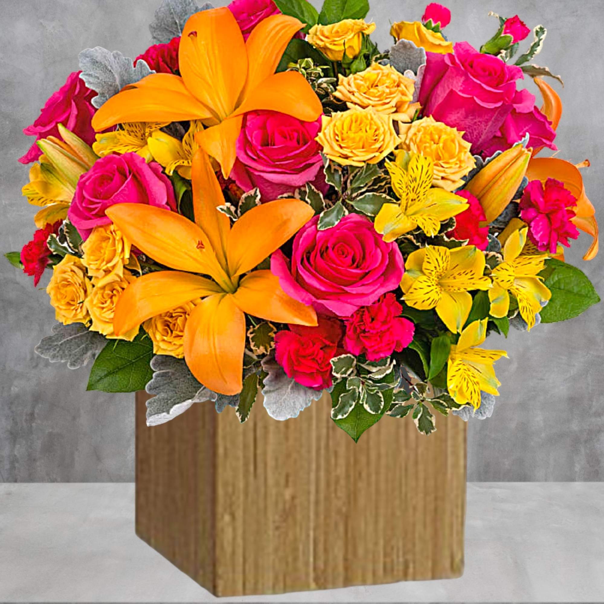 Bright bouquet of pink and yellow flowers in a wooden box