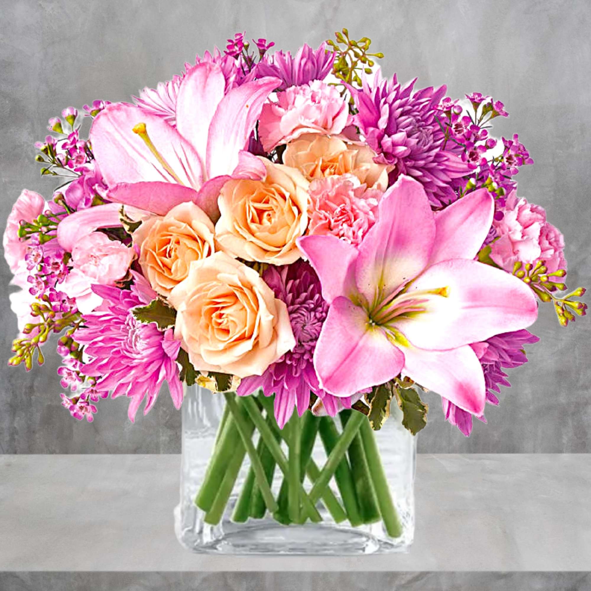 Pink and peach bouquet of lilies, roses, and chrysanthemums in a clear glass vase, photo 2 of 5