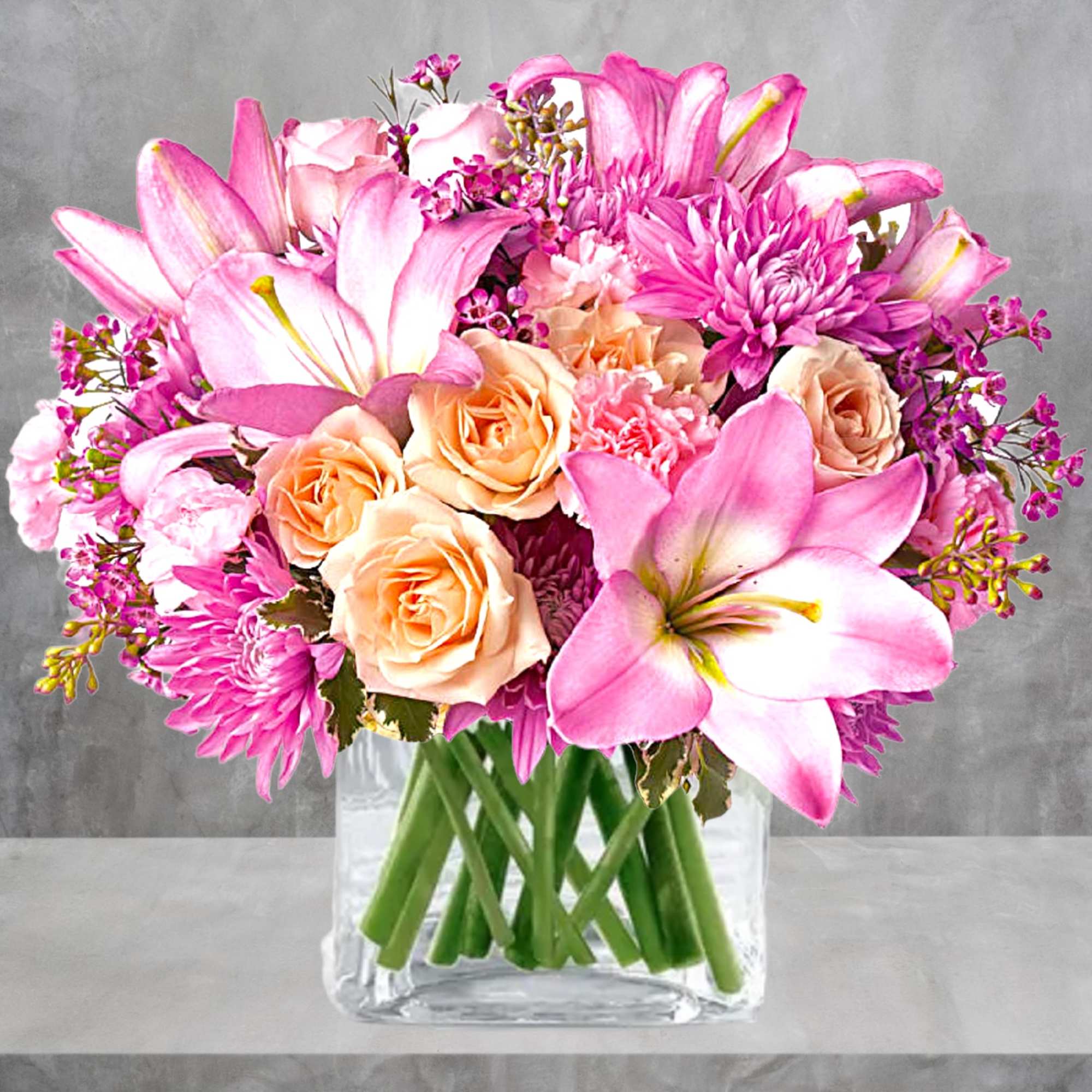 Pink lilies and peach roses in a clear glass vase, photo 2 of 5