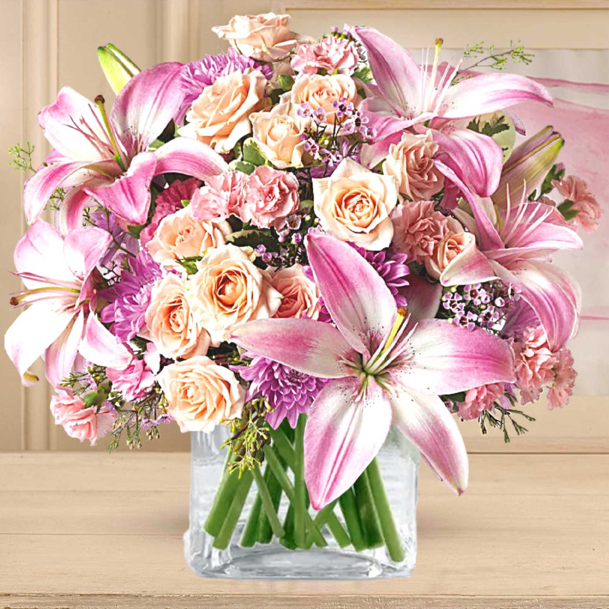 Pink lilies and peach roses arranged in a clear glass vase, photo 3 of 5