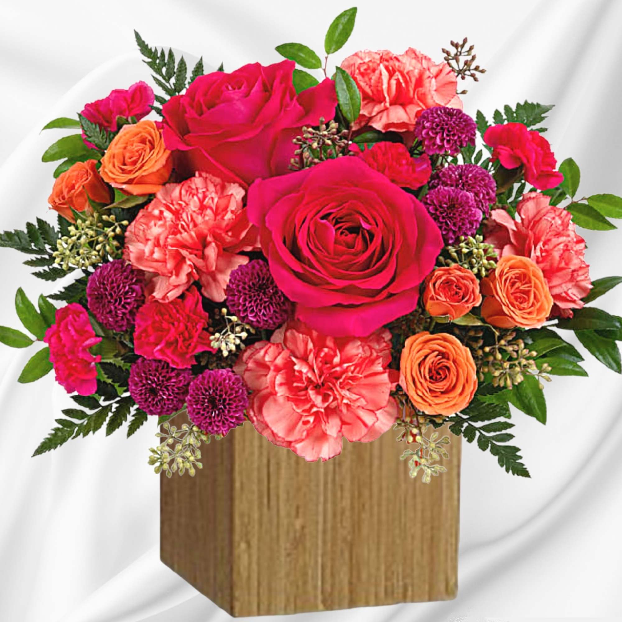 Bright pink and orange flower arrangement in a wooden box