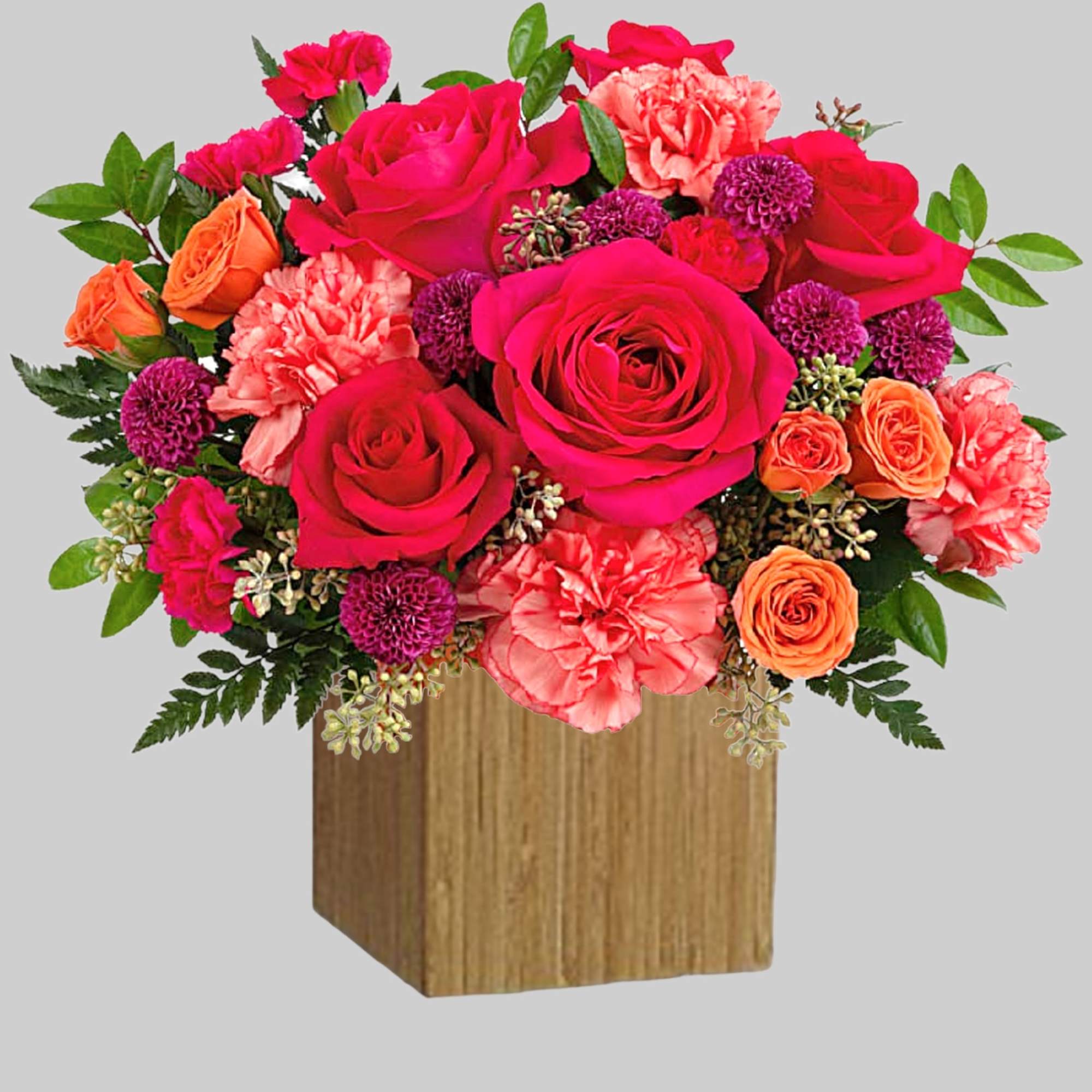 Bouquet of pink, red, and orange roses in a wooden cube vase