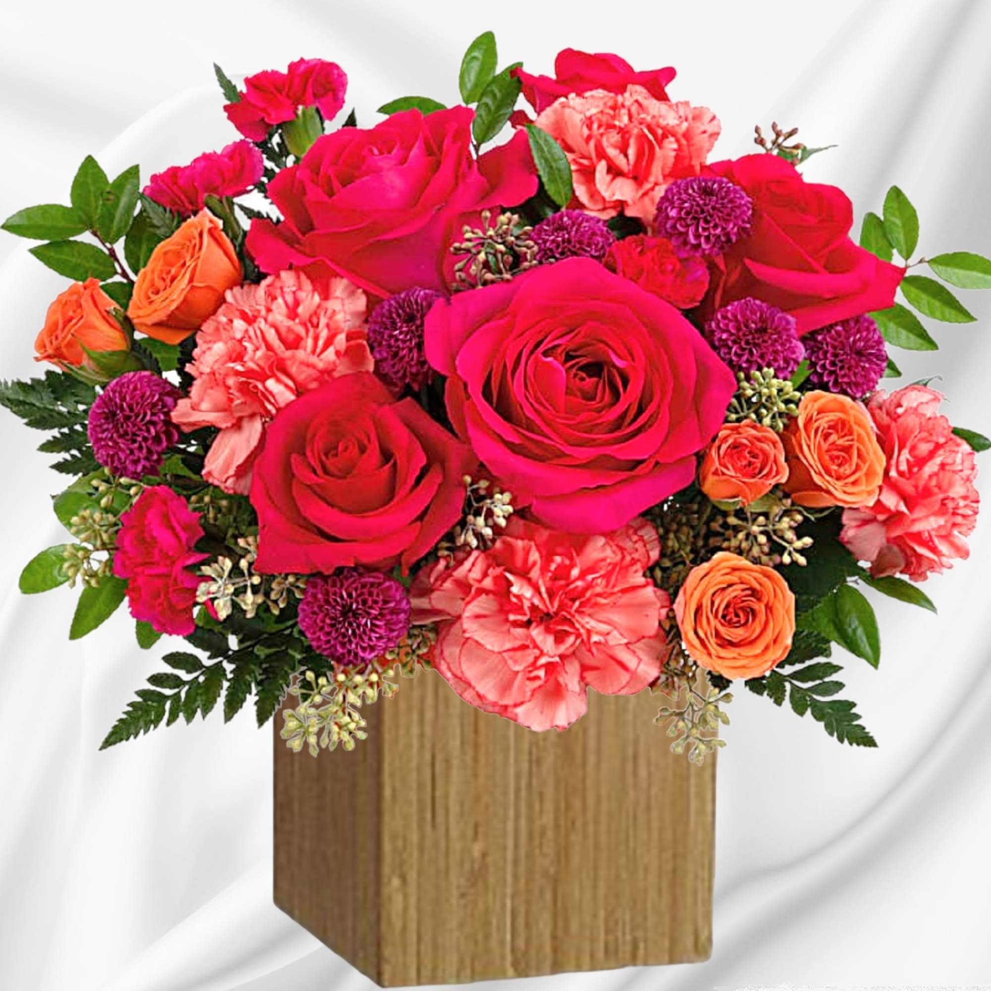 Bright mixed bouquet of roses and carnations in a wooden box