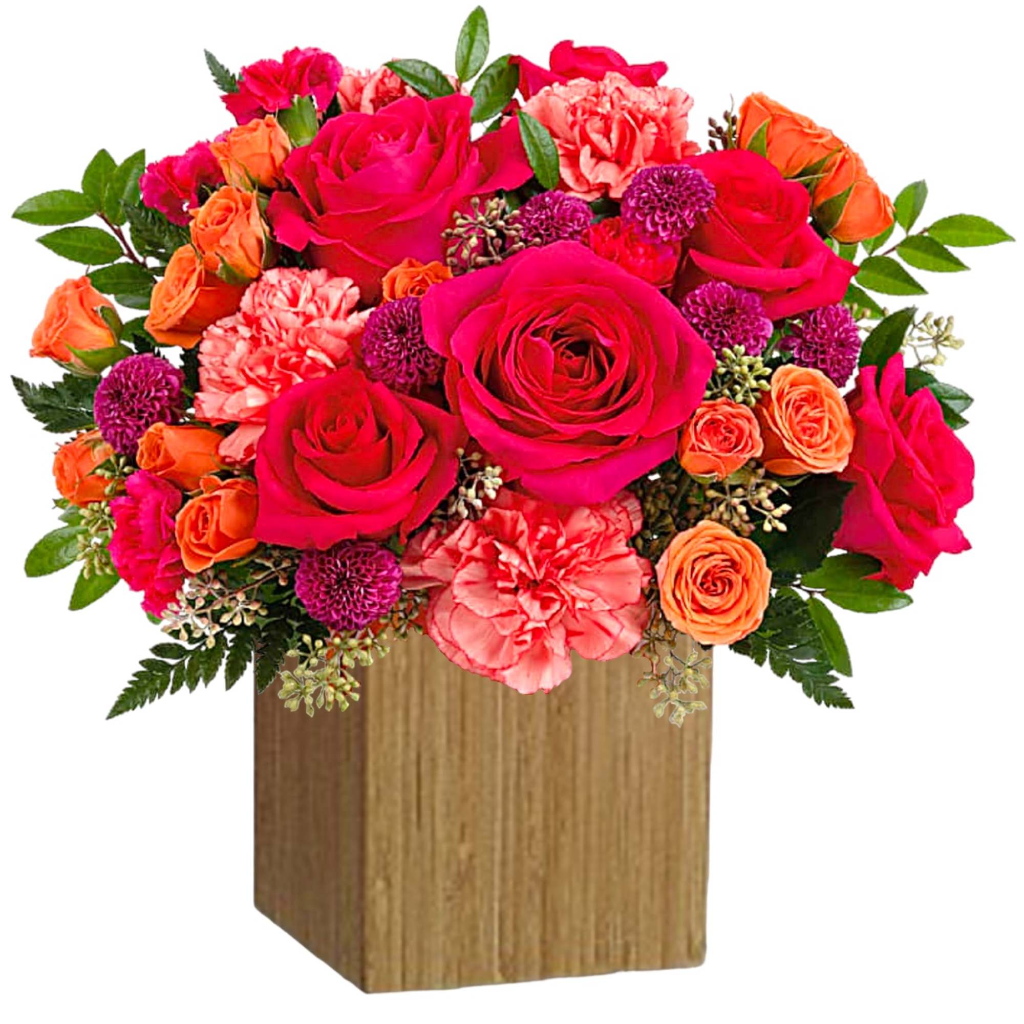 Bright mixed bouquet of roses and carnations in a wooden cube vase